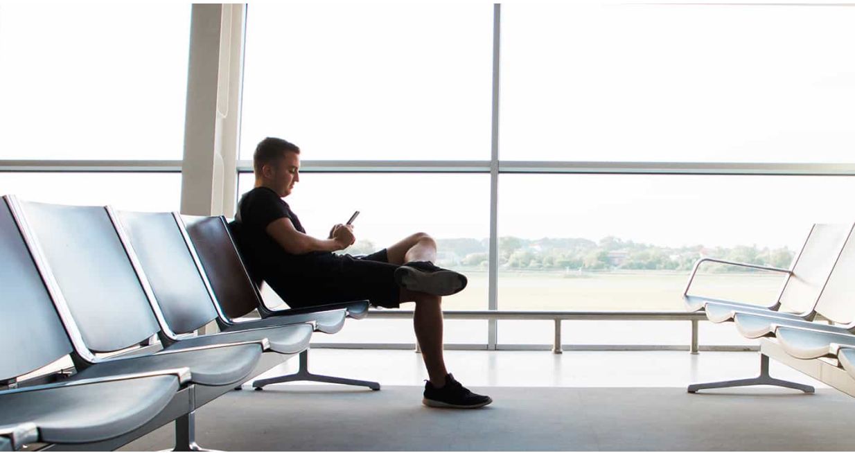 Man sitting in airport reading on Glowlight 4