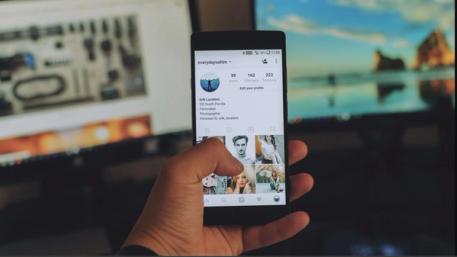 Phone in hand opened to an instagram account page