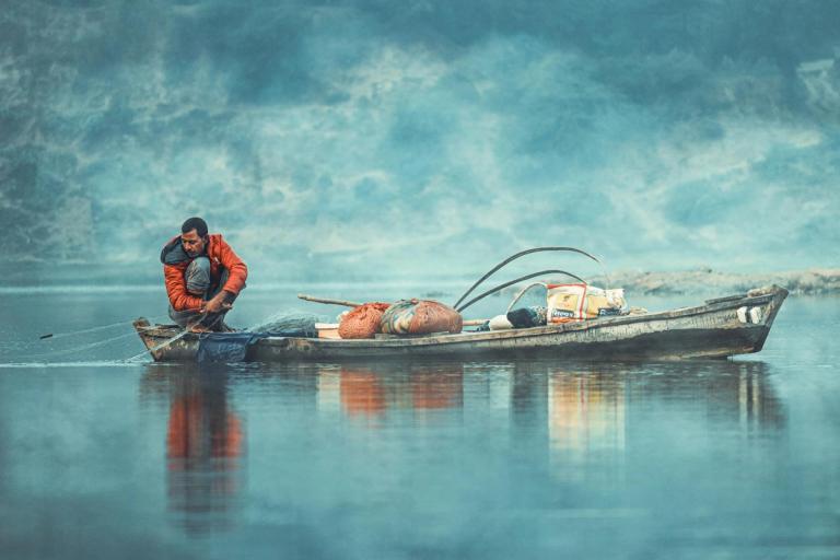 a large jon boat on a lake loaded with fishing gear, illustrating the need for adequate size
