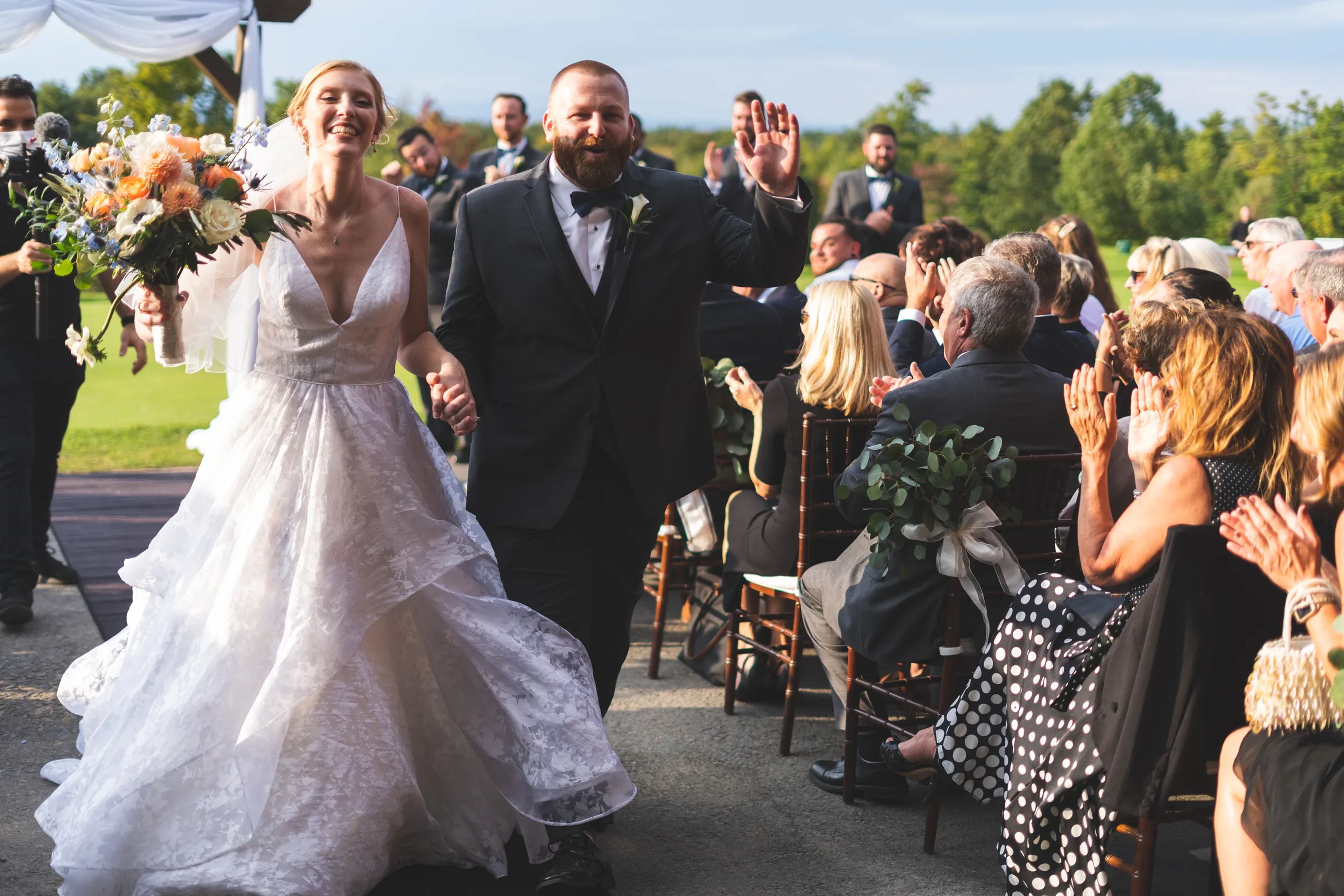 Newlyweds celebrating their wedding exit as guests cheer around them