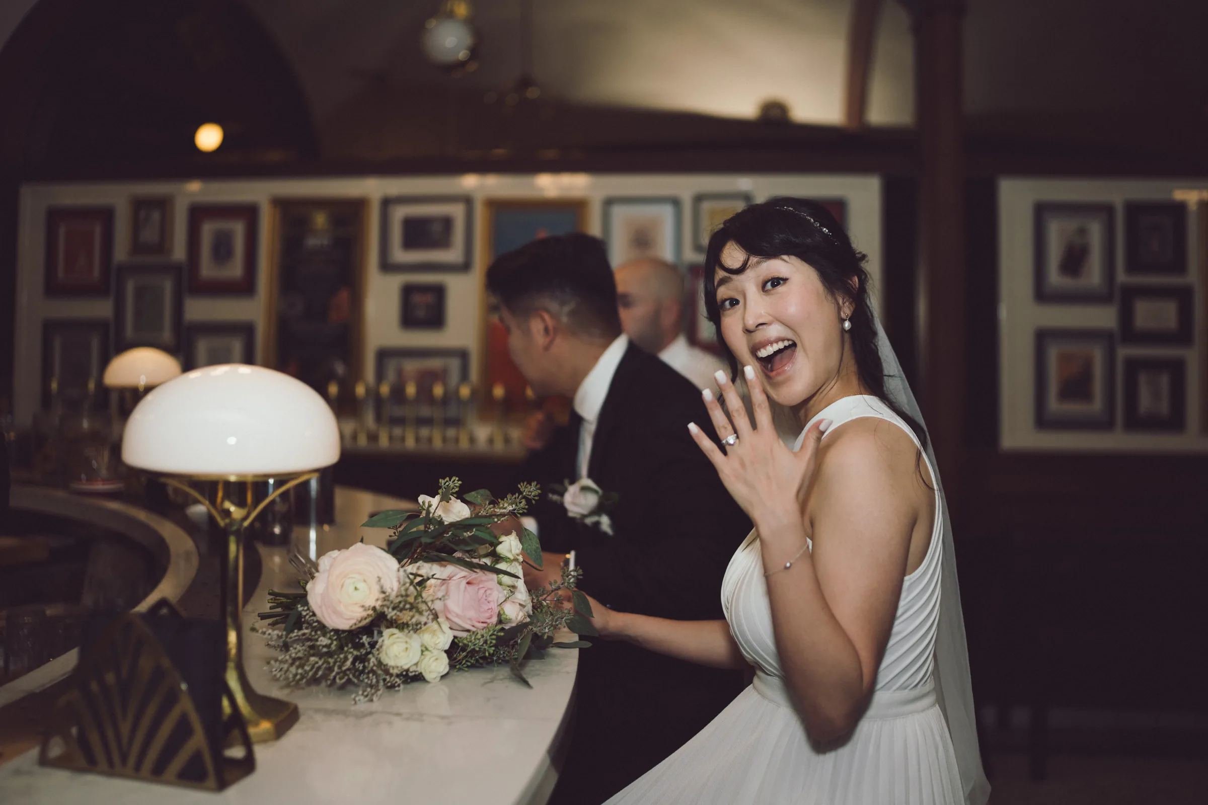 Bride laughing with her groom in a warmly lit reception room