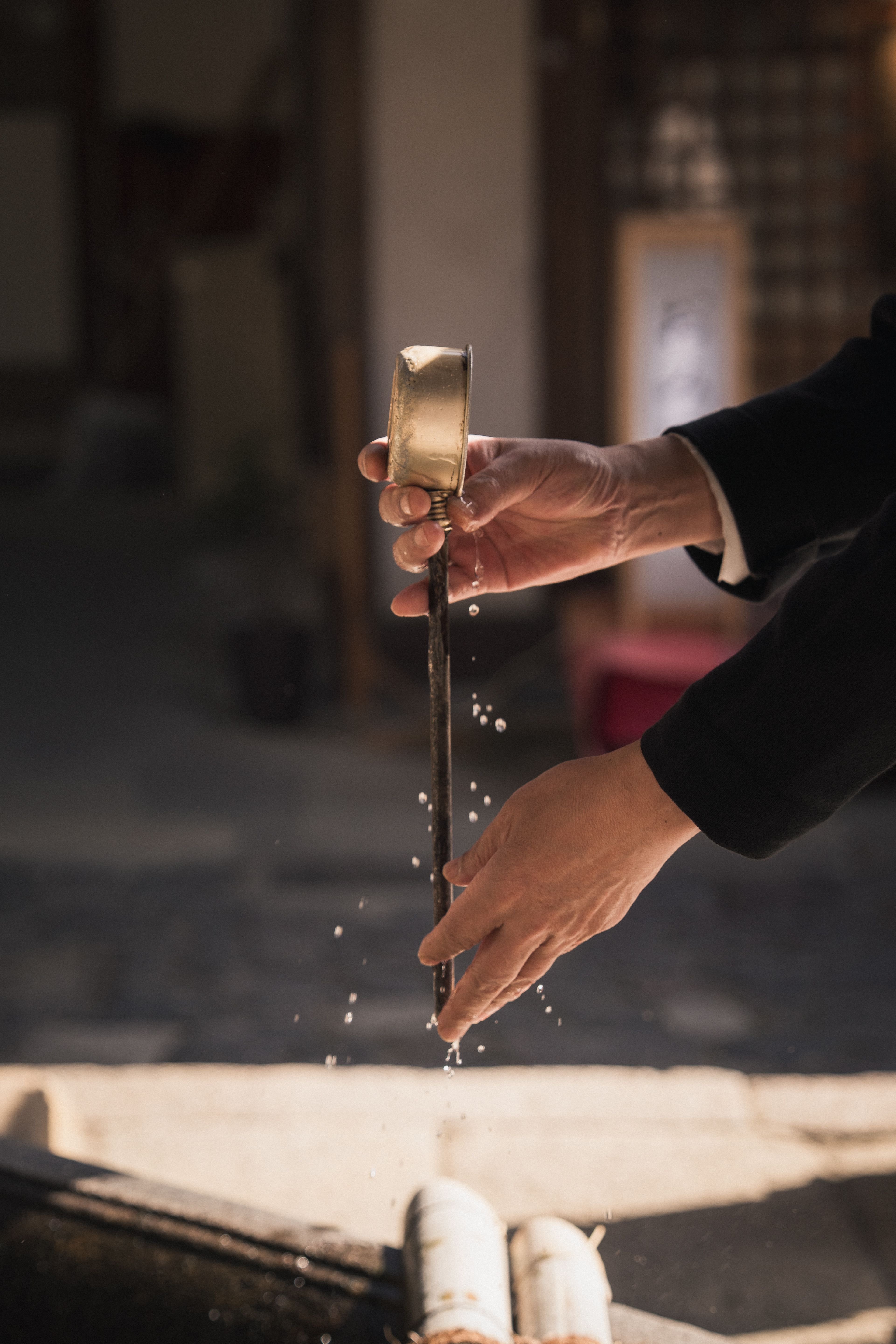 Temizu — The ritual ends by rinsing the handle, leaving it clean for the next person