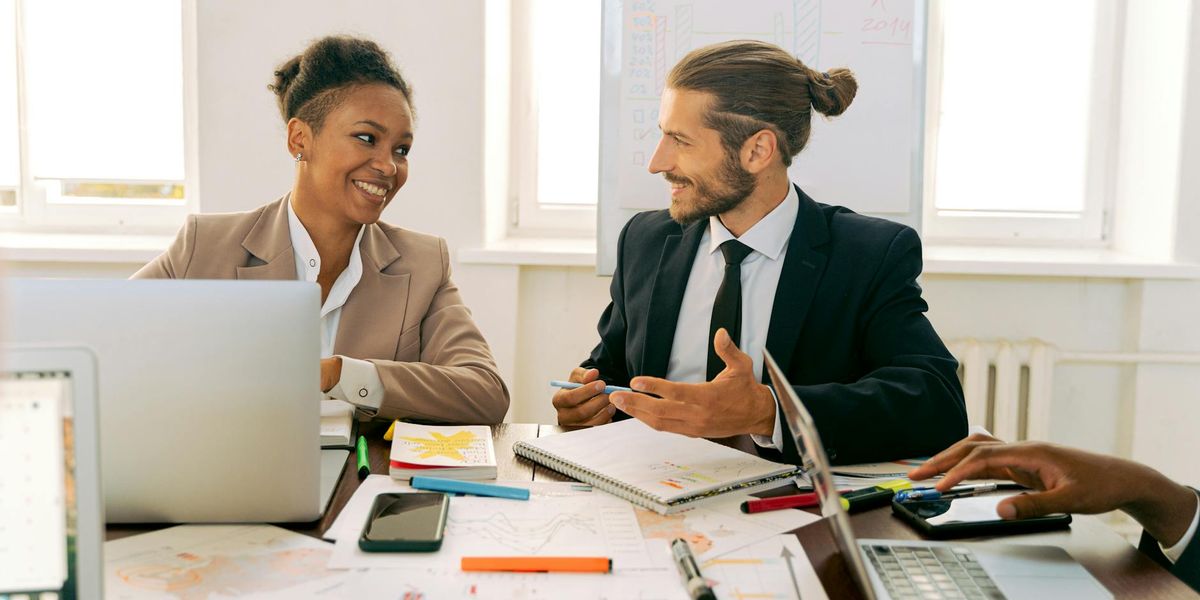 A diverse group of professionals engaged in a financial discussion, showcasing modern budgeting tools in a UK setting.