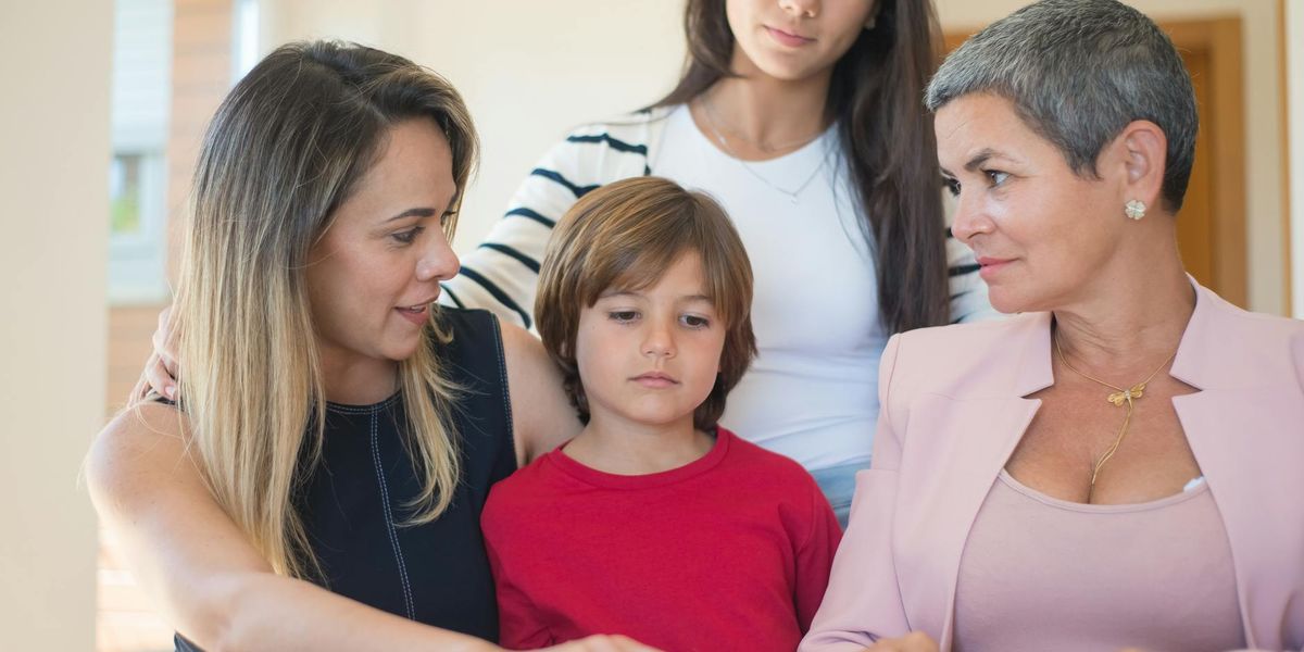 A diverse family discussing financial planning in a modern home office, representing the balance of saving and supporting loved ones abroad.