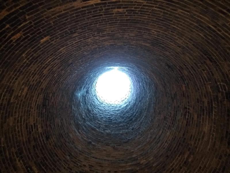 Looking up inside a bottle kiln, seeing the light at the top