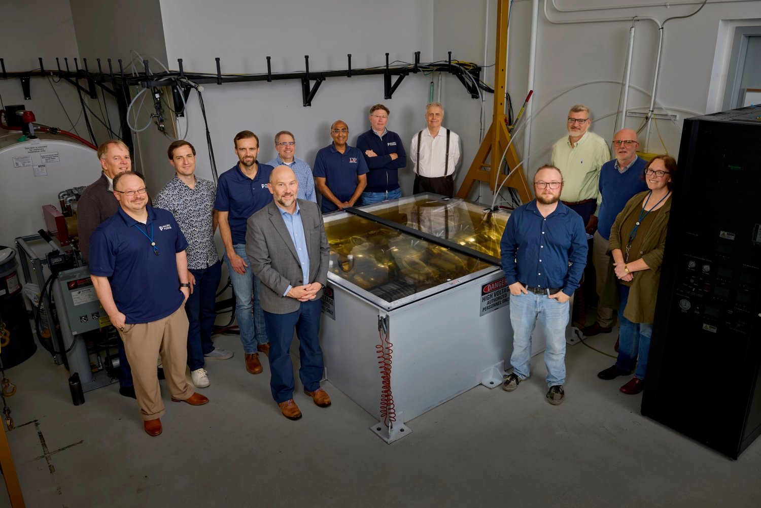 Pacific Fusion and Lawrence Livermore researchers standing around the SIRIUS pulsed-power prototype in a laboratory.