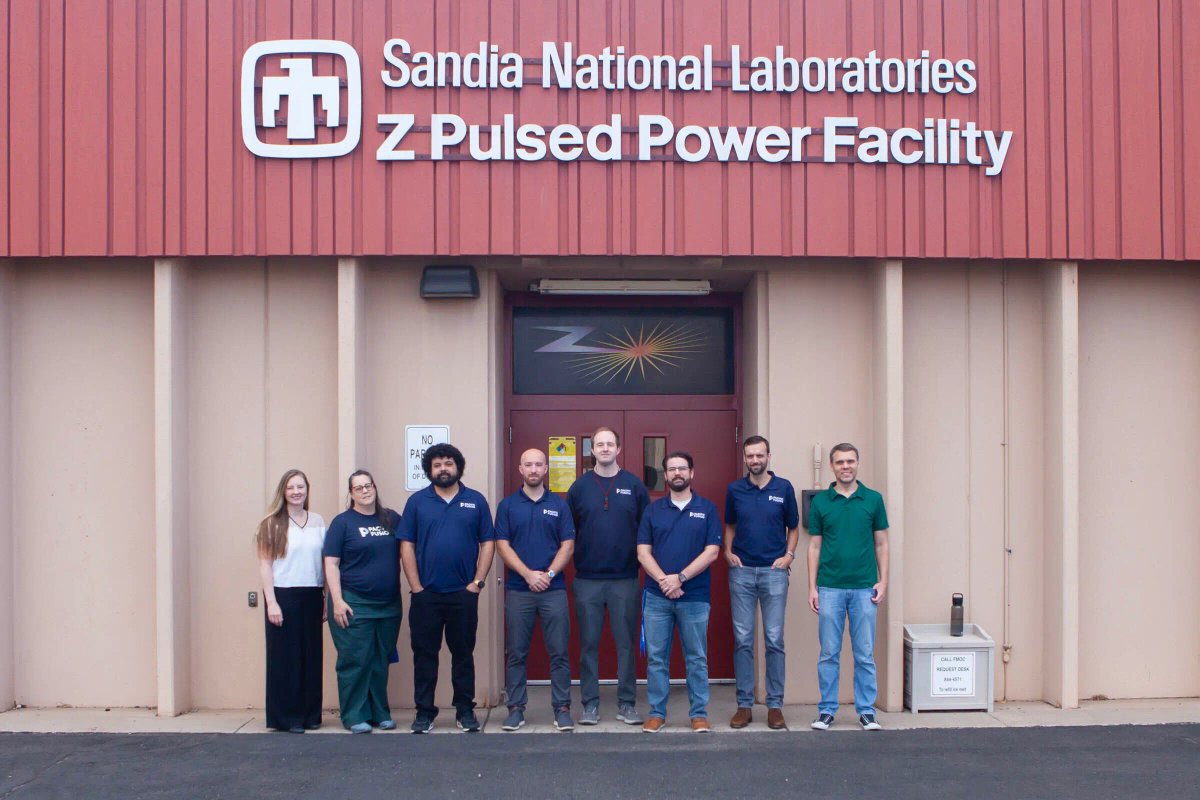 Pacific Fusion team members standing in front of the Sandia National Laboratories Z Pulsed Power Facility.
