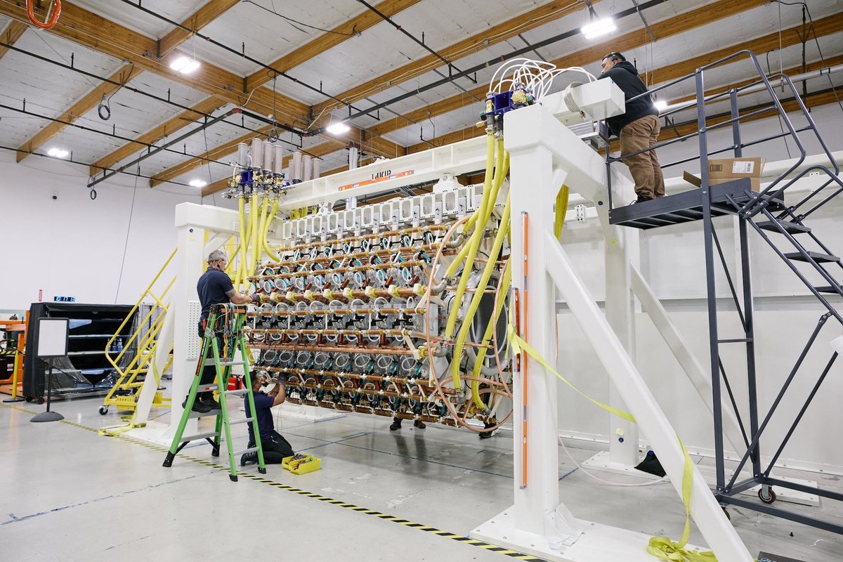 Pacific Fusion engineers working on the scaled pulser-module prototype in the laboratory.