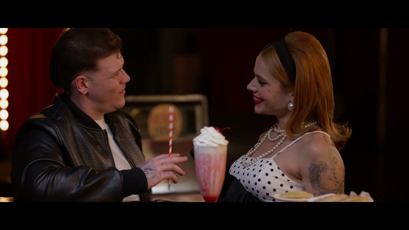 Ferrugem e Thaís Vasconcellos em cena de lanchonete no clipe Amar ou Odiar