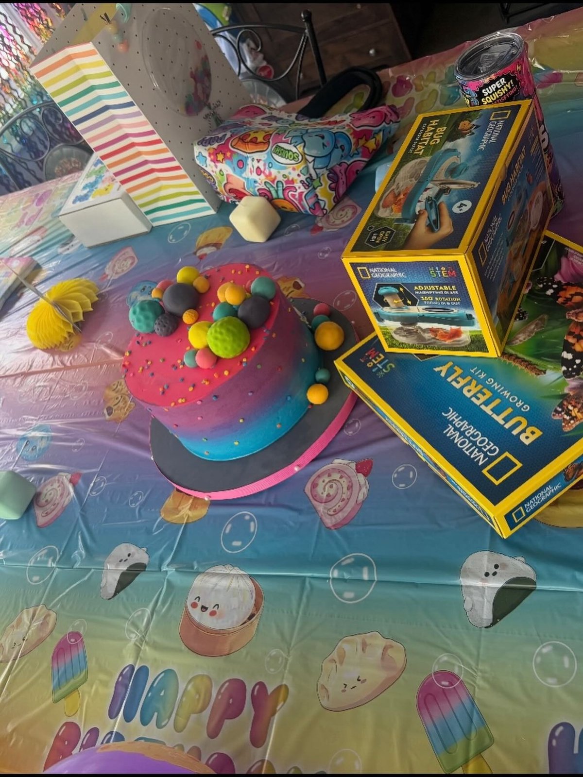 Bolo colorido e brinquedos na comemoração dos 6 anos de Khai