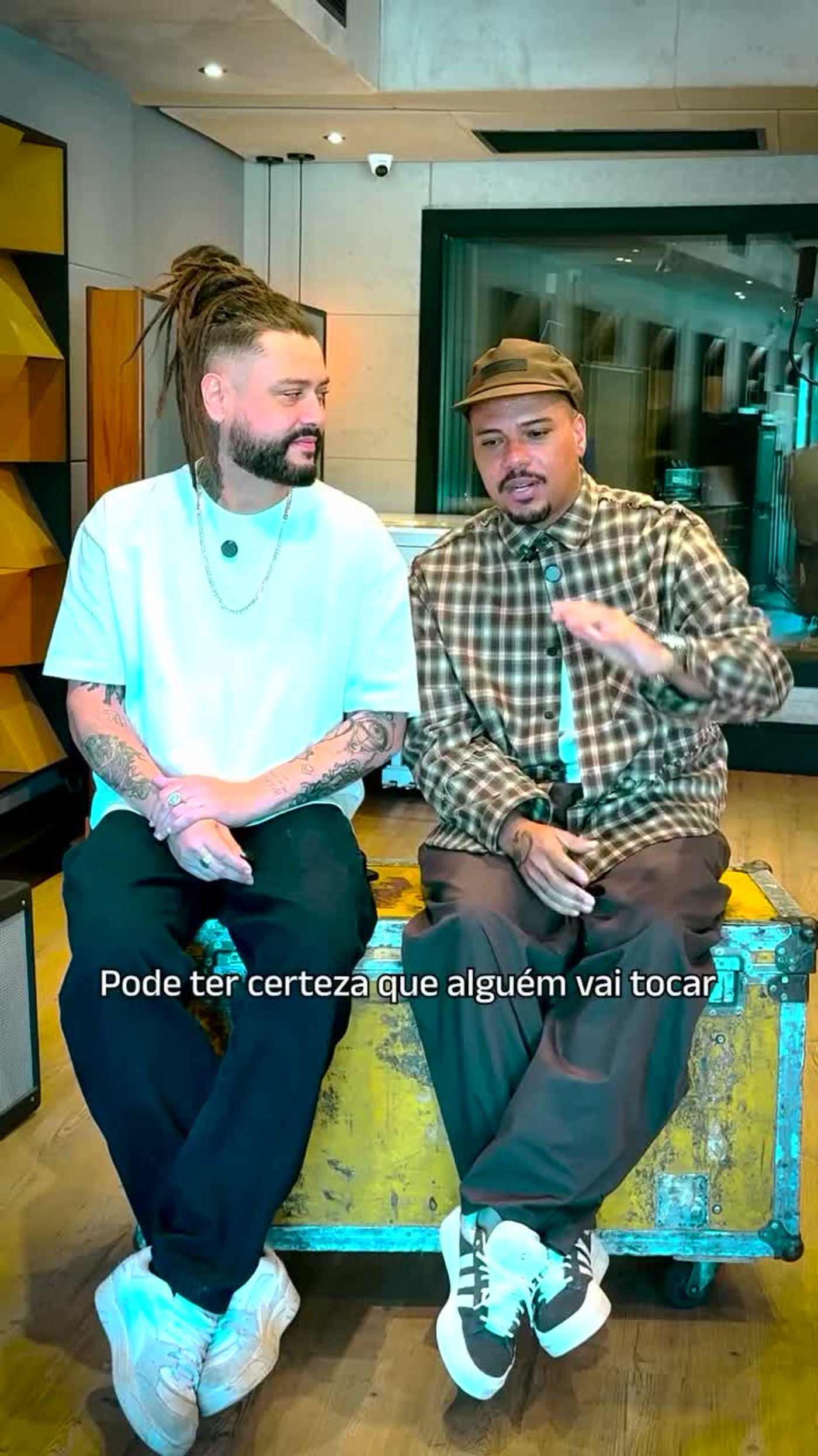 Tales de Polli e Bruno Cardoso sentados durante o vídeo da playlist Pagoreggae