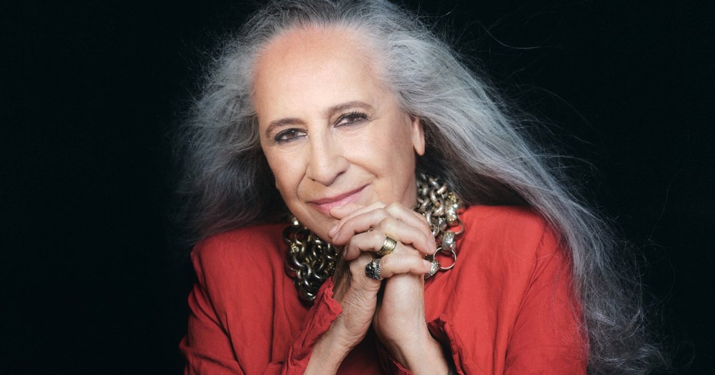 Maria Bethânia em retrato de divulgação vestindo vermelho
