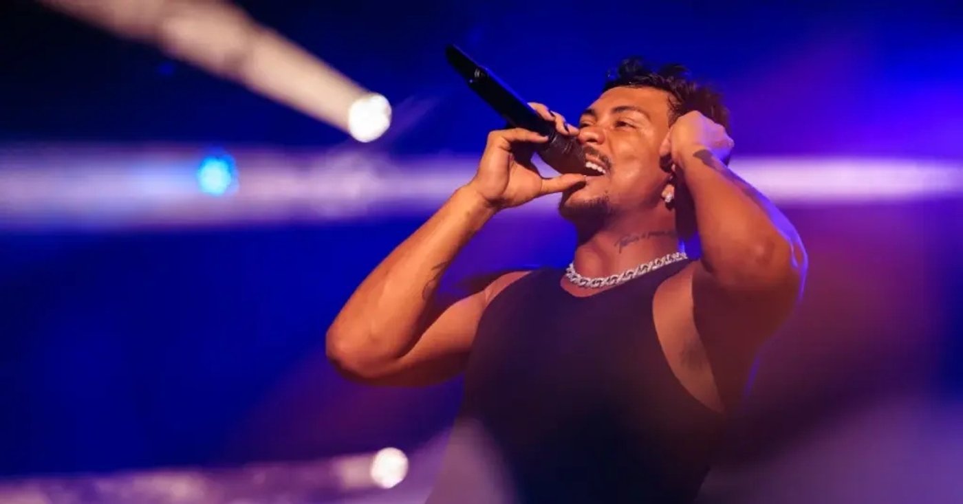 Xamã canta ao microfone em uma apresentação