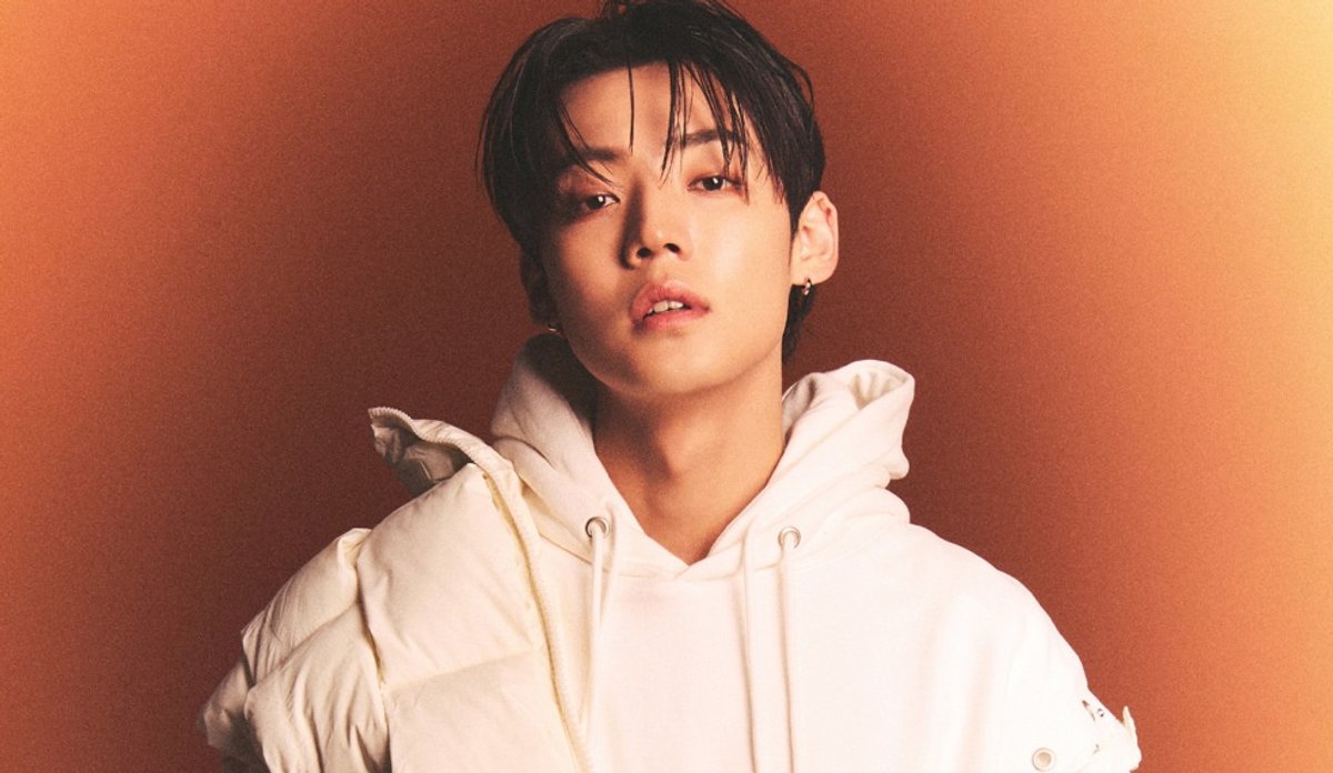 Kang Yuchan em retrato de divulgação com roupa clara.
