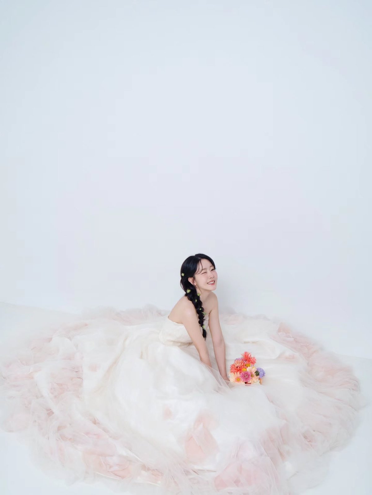 Yujeong sentada com vestido de noiva e buquê rosa
