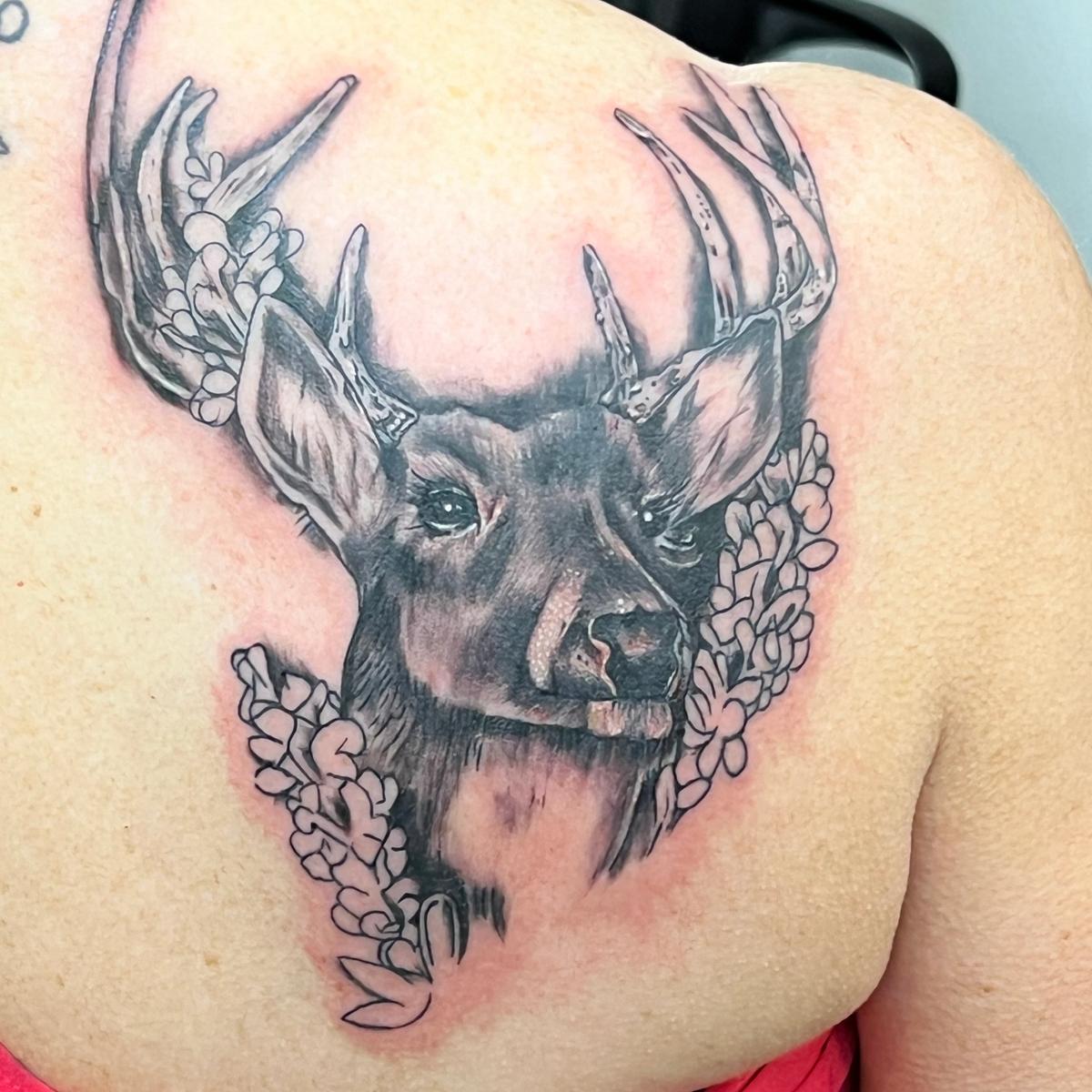 A black and grey deer on the shoulder
