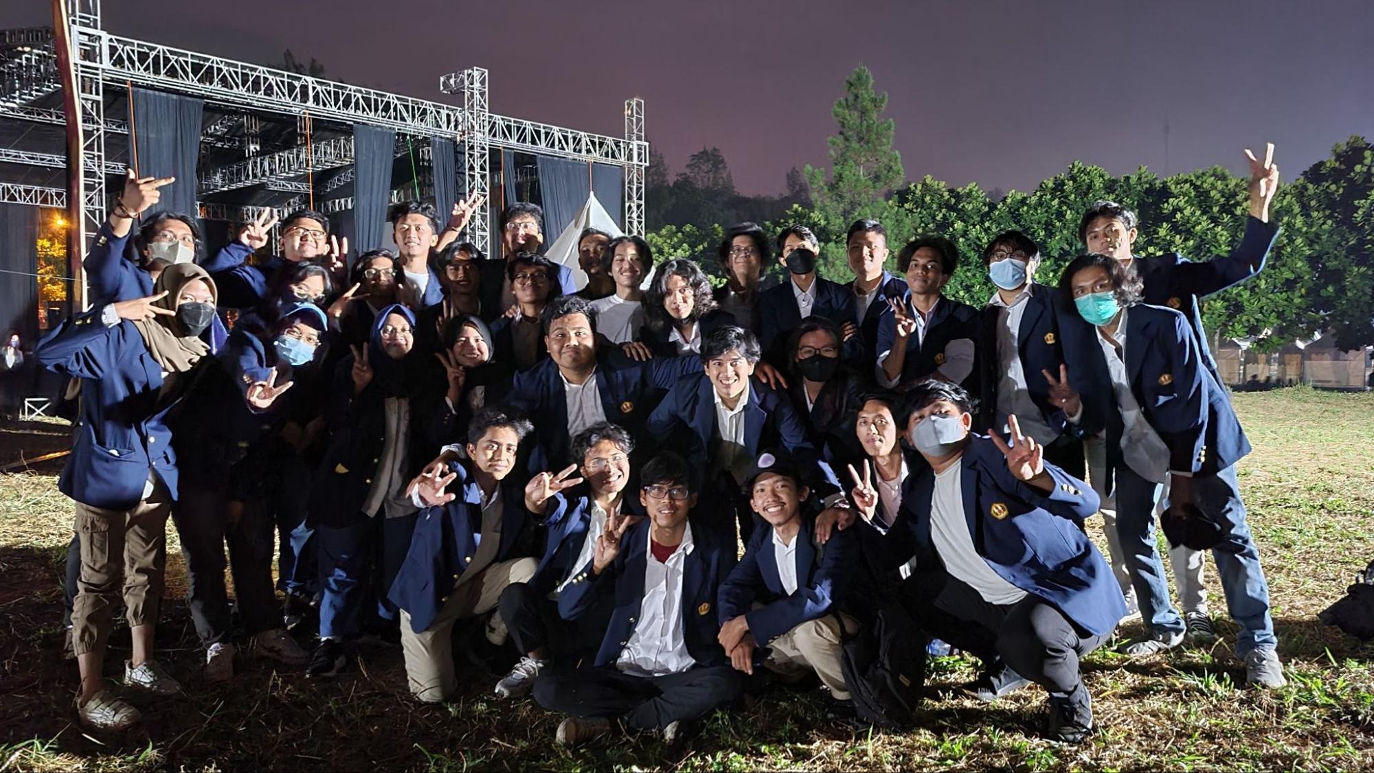 Foto bersama tim kepanitiaan festival film pada malam hari
