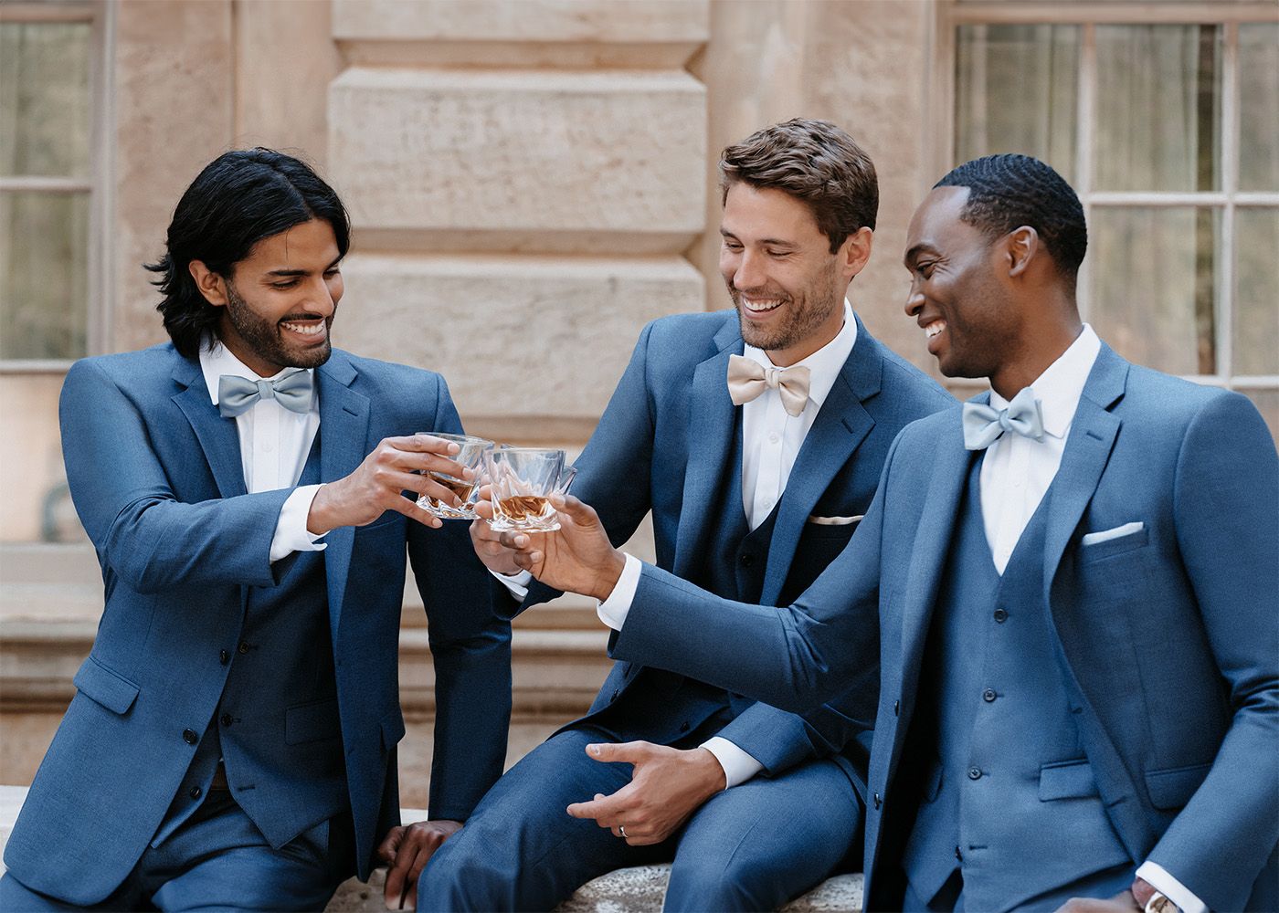 Three men toasting in blue tuxedos 