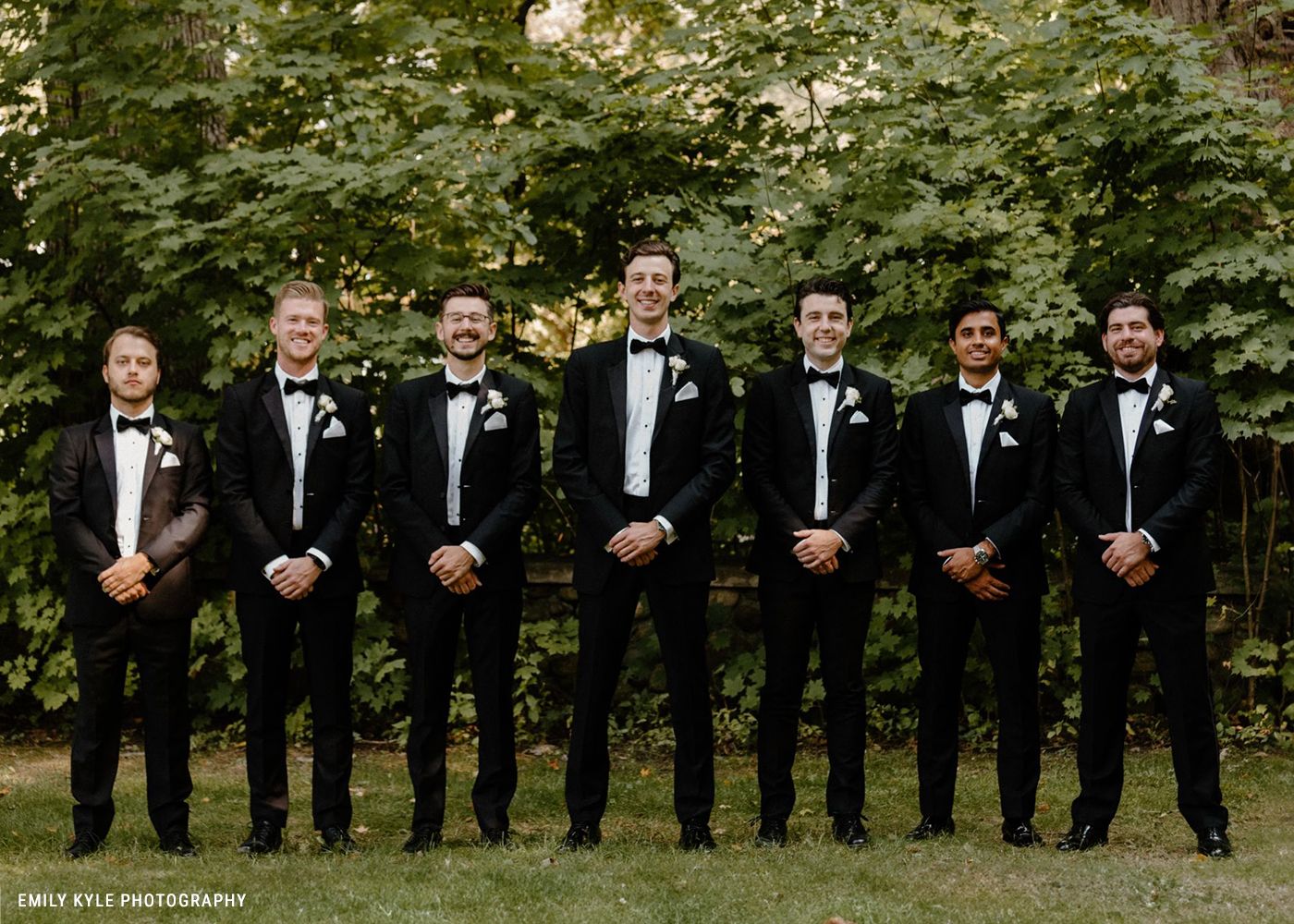 Seven men in suits standing in a line