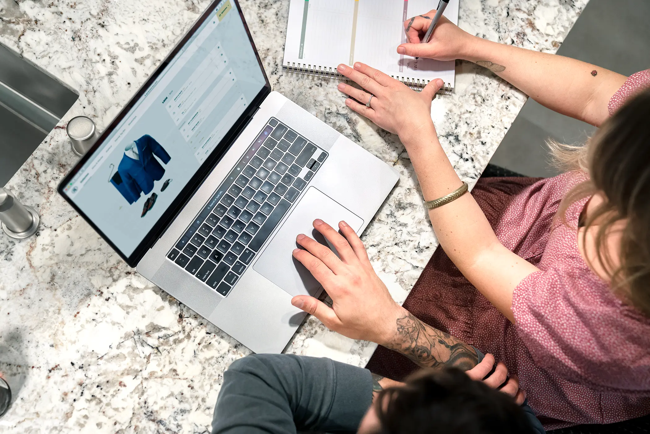 Couple sitting at computer, planning out their wedding looks