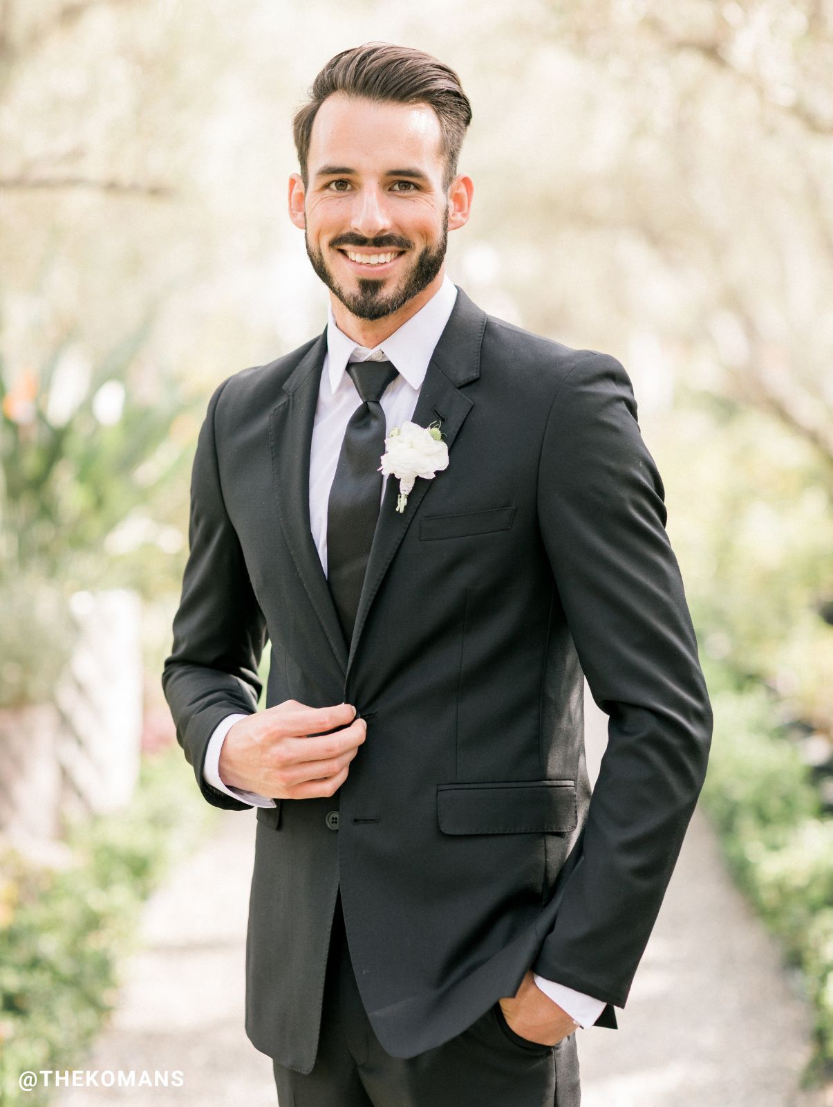 A man in a black suit standing in front of others