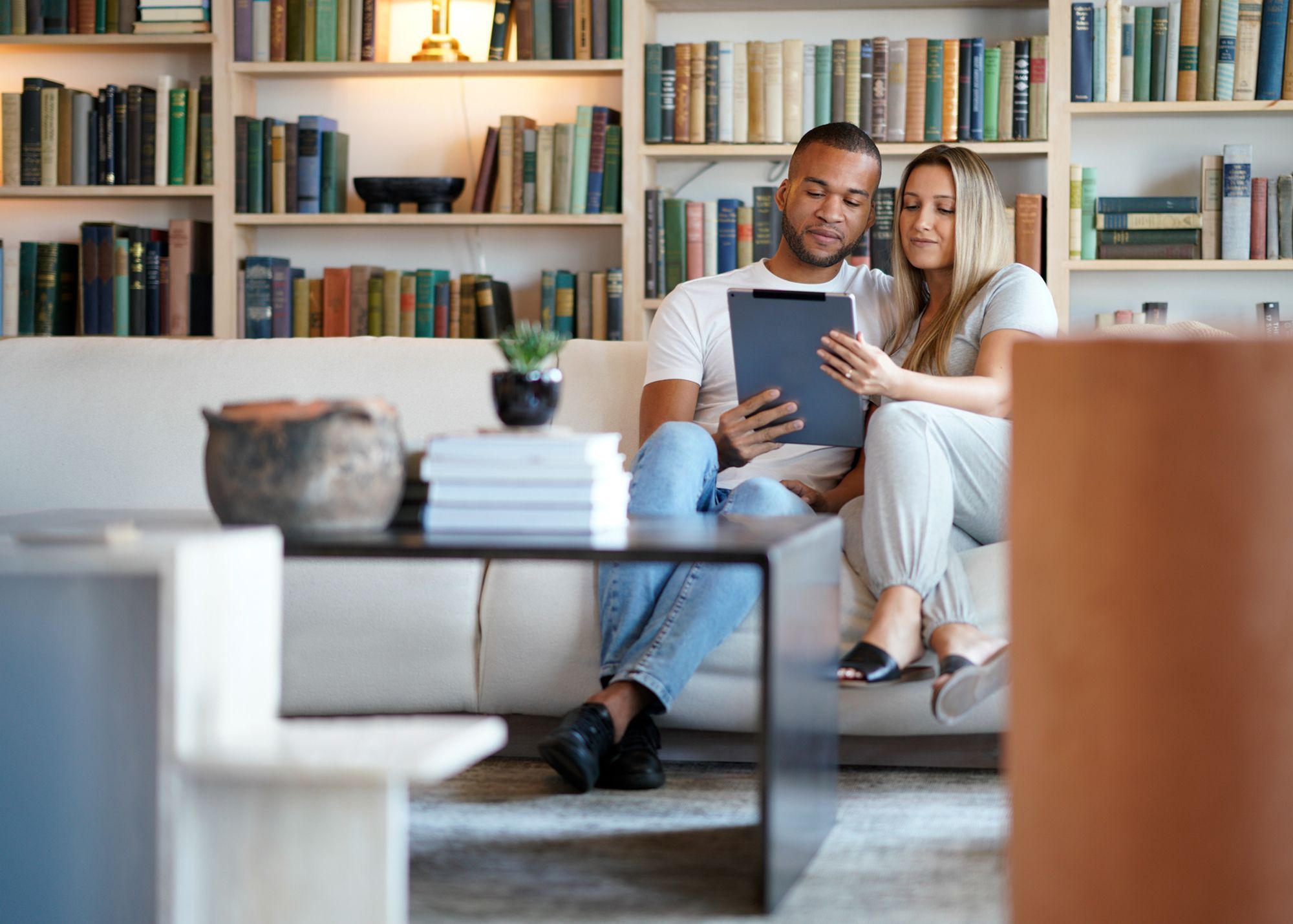 Couple sitting on the couch together looking at an ipad