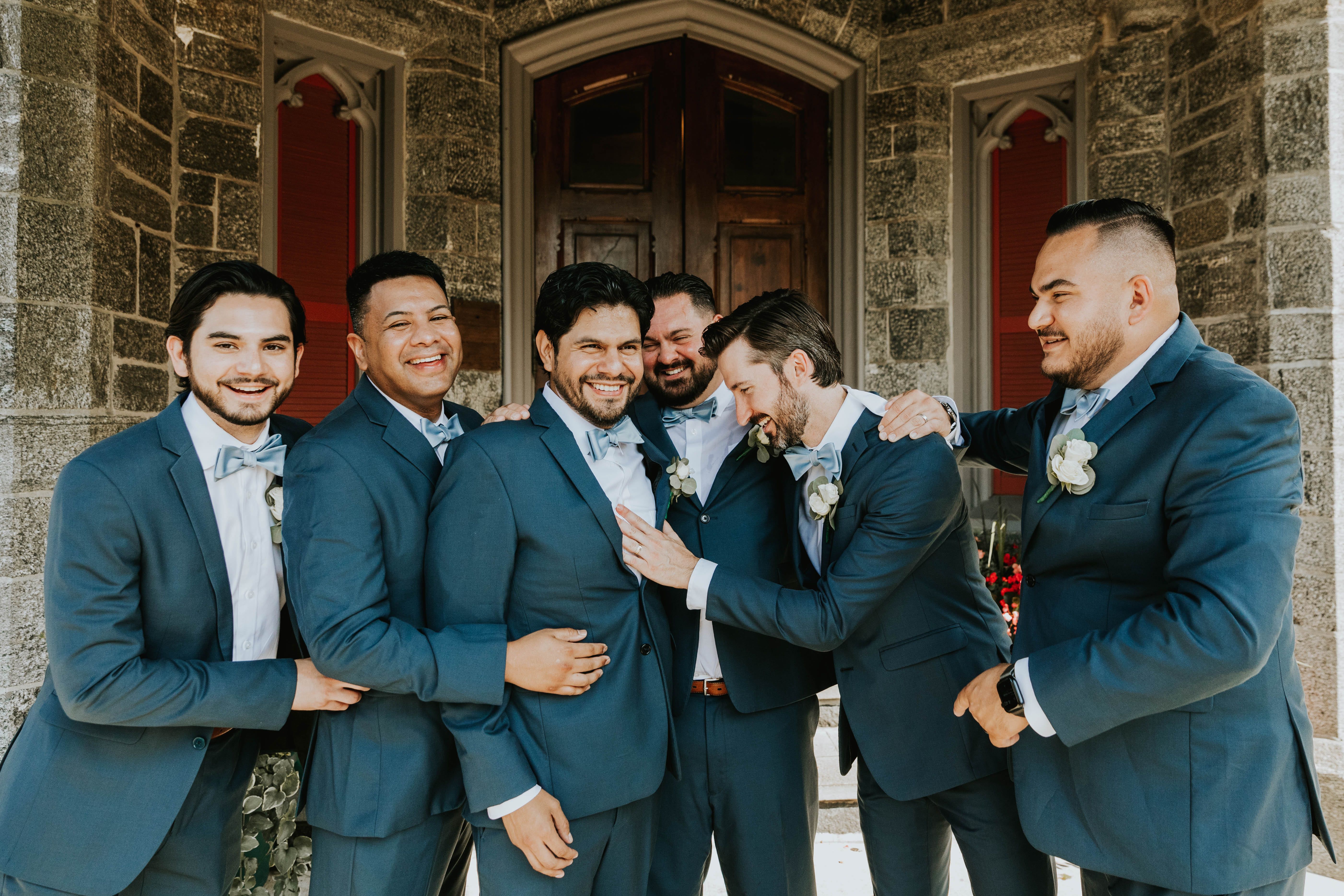 Groomsmen in blue suits laughing