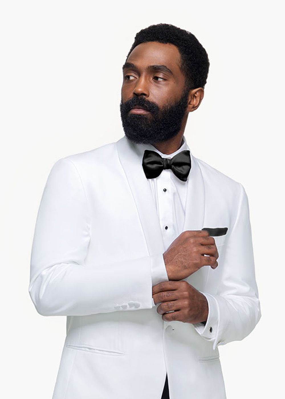 A man in a white tuxedo with a black bow tie 