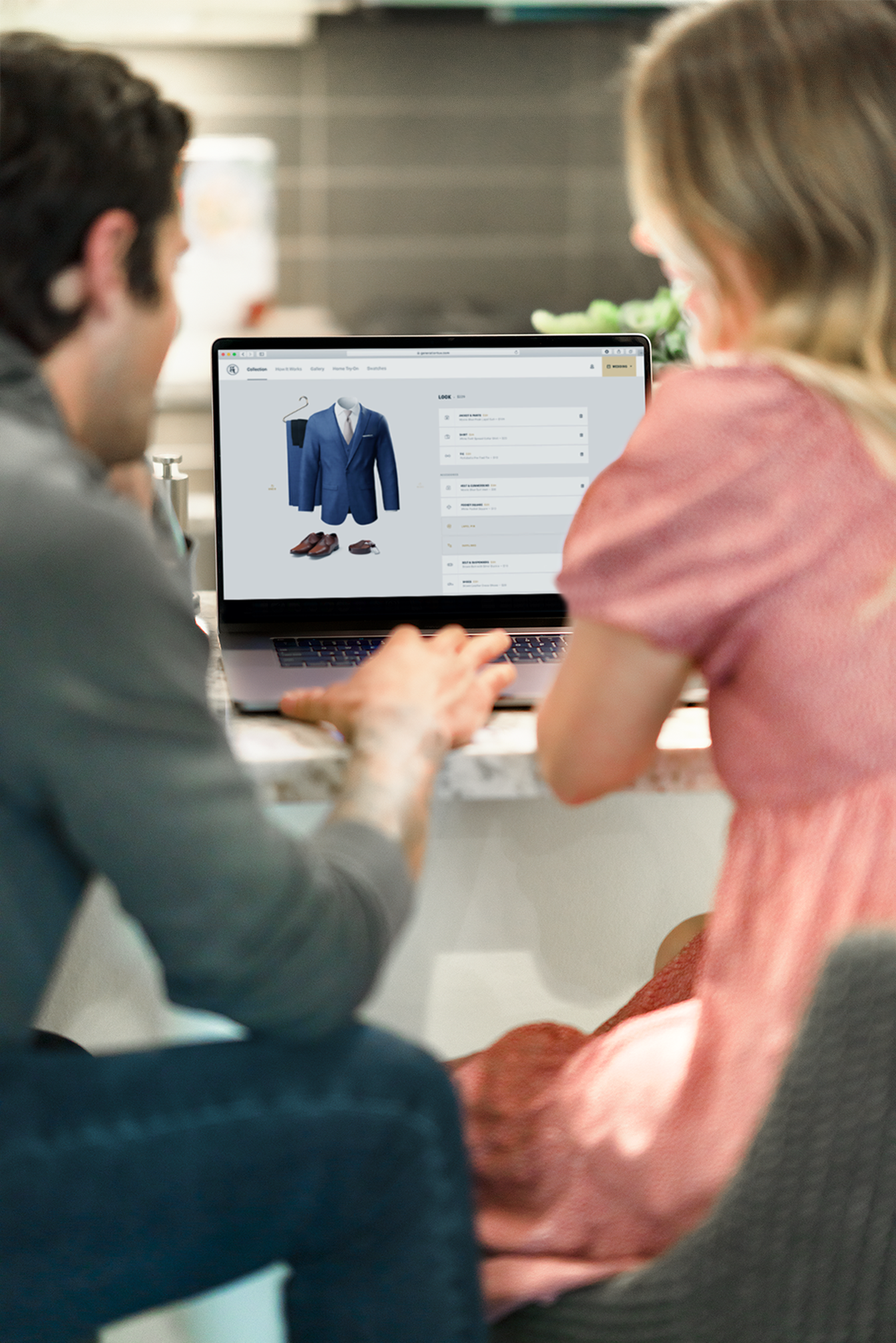 Couple sitting at the counter looking at a suit on their computer
