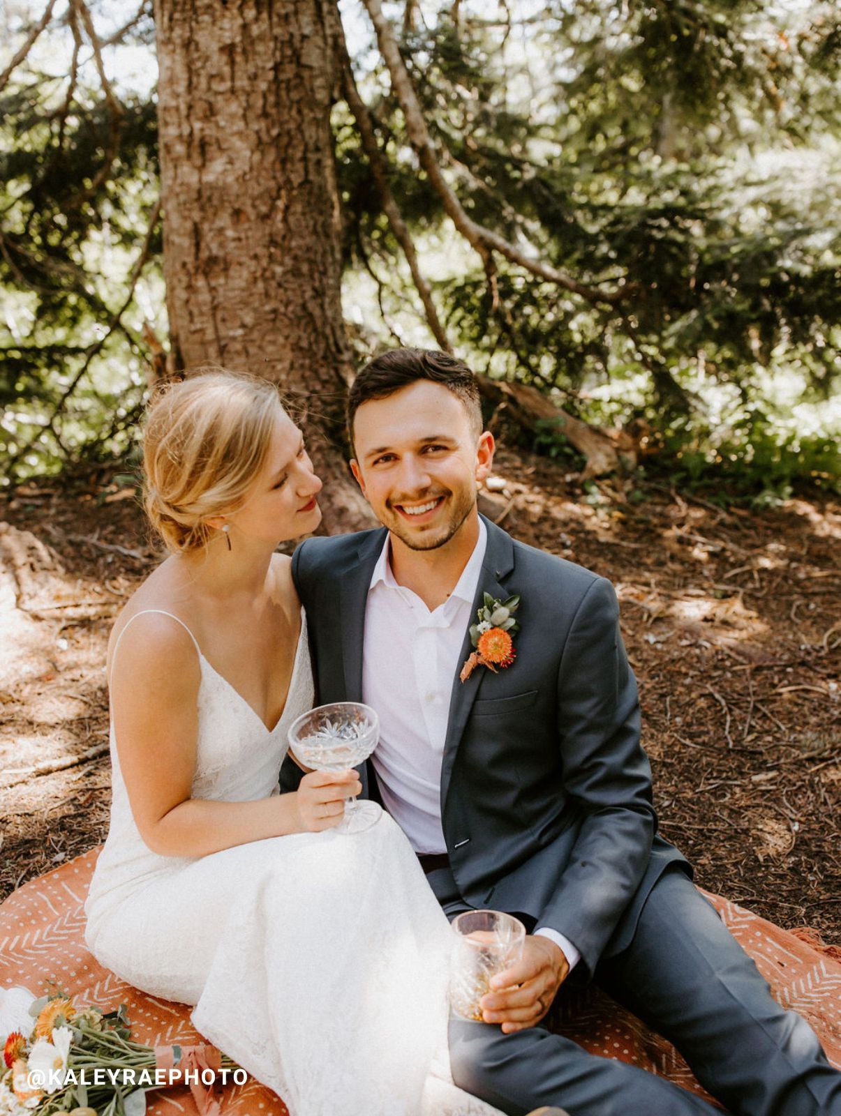 Groom sitting down wearing Generation Tux wedding suit next to bride.