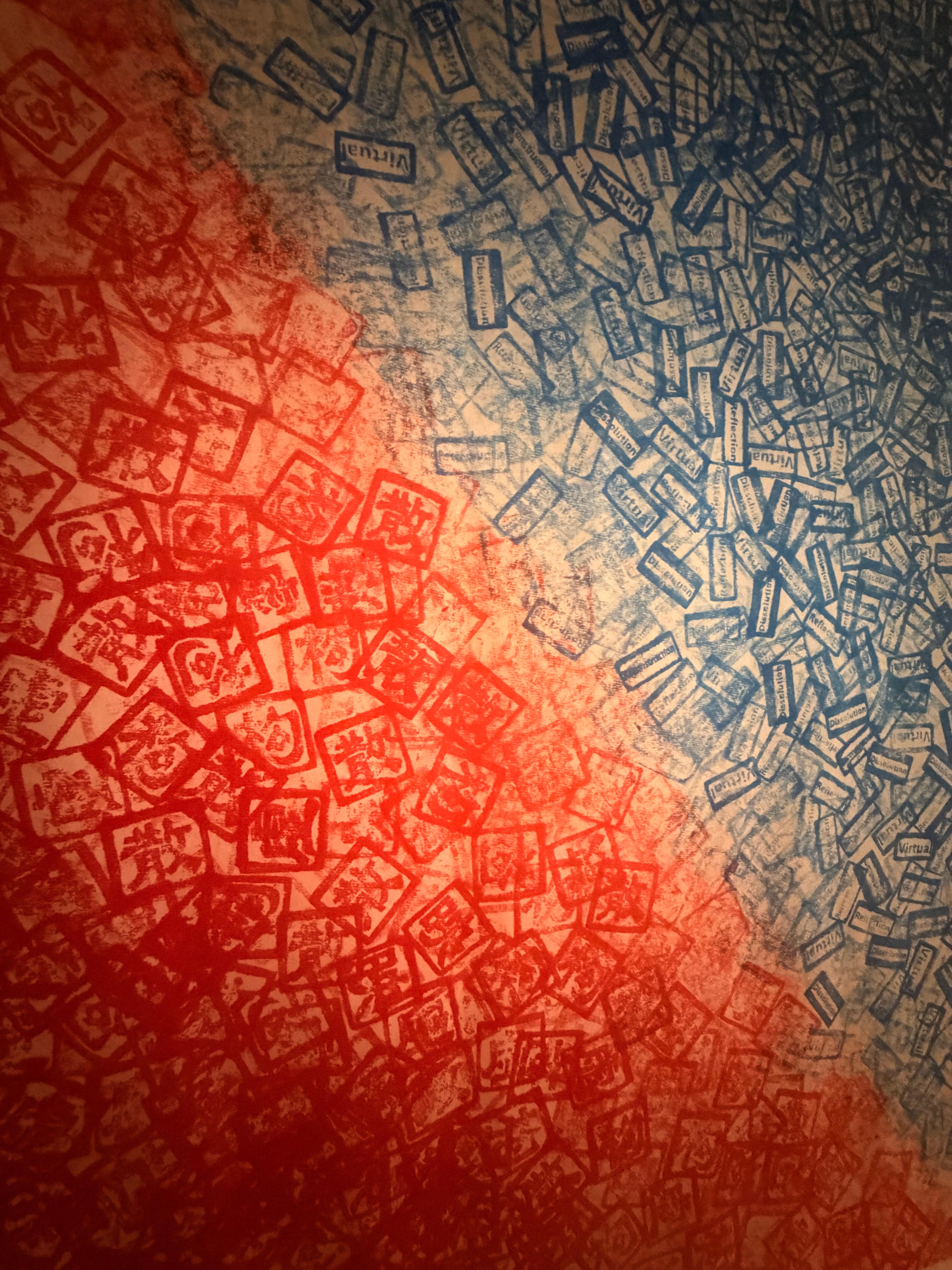 Close-up of overlapping red and blue stamped text on canvas