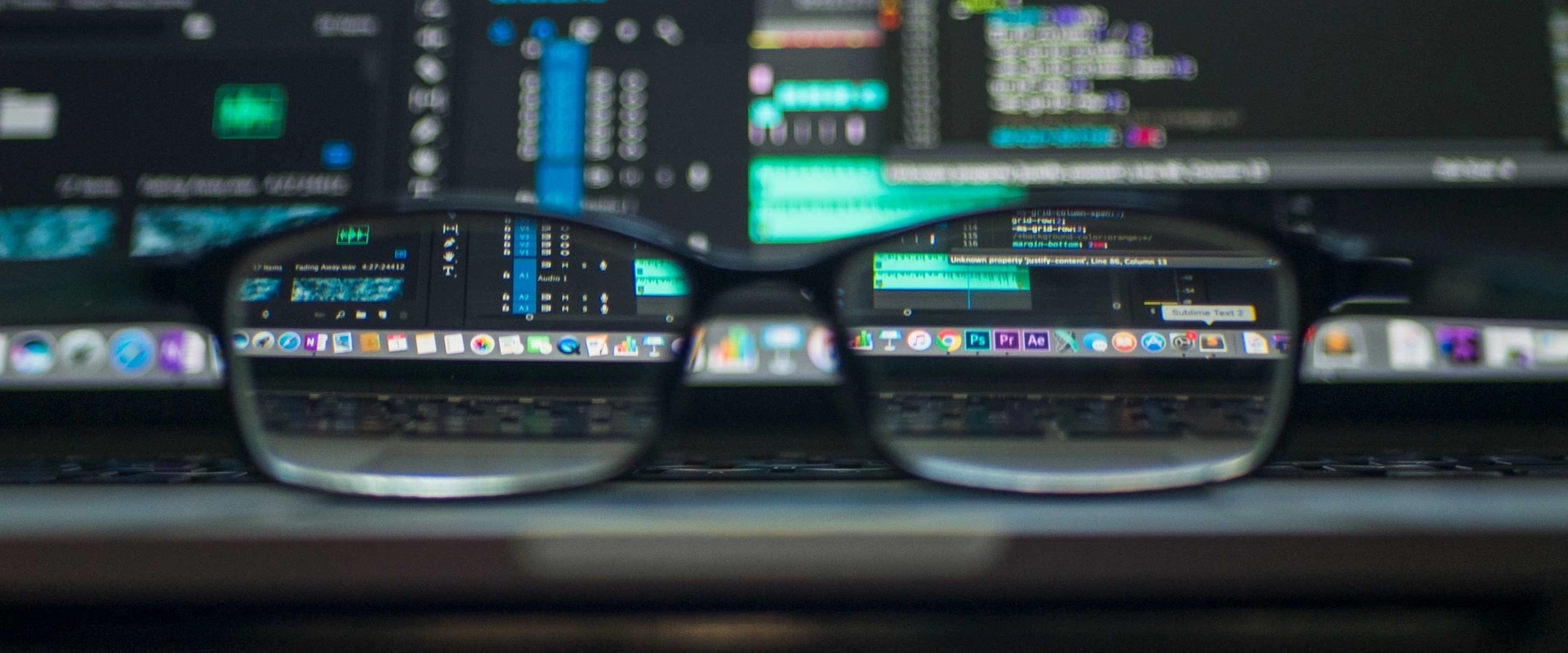 Glasses in front of a computer monitor showing code