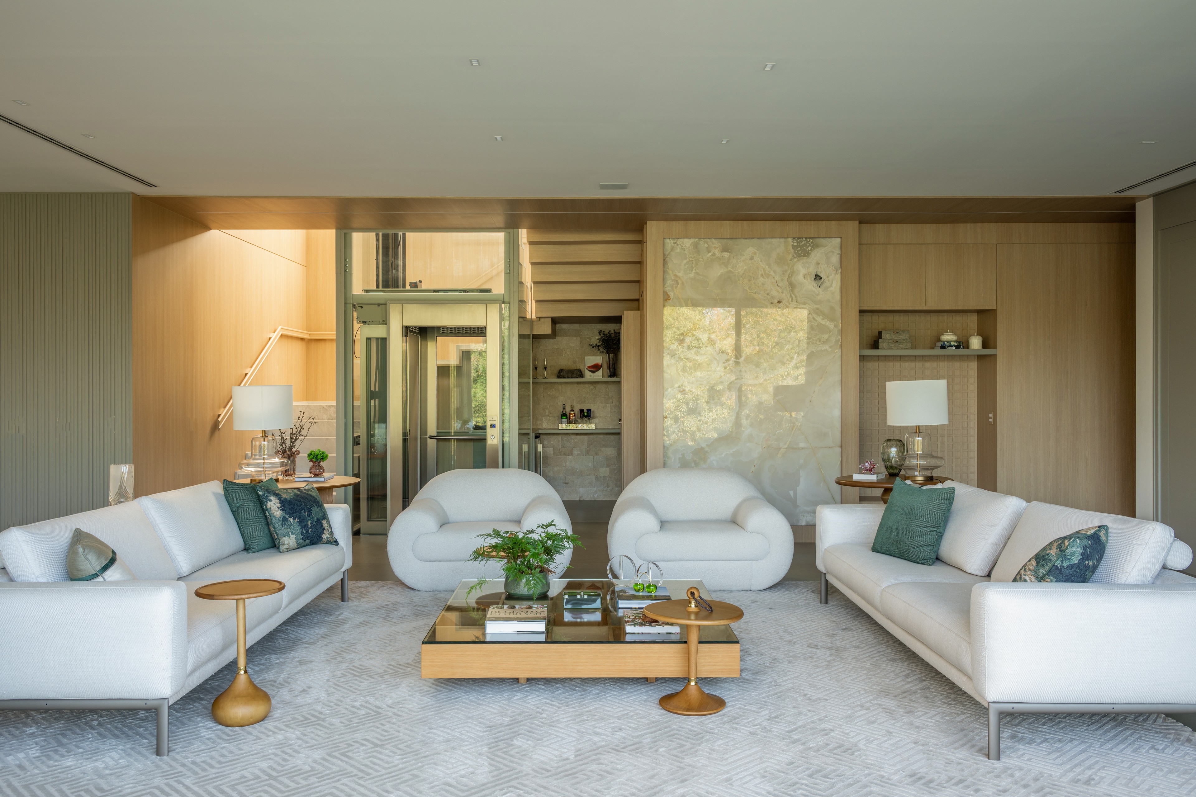 Residência SMI — Sala de estar com poltronas e painéis de madeira