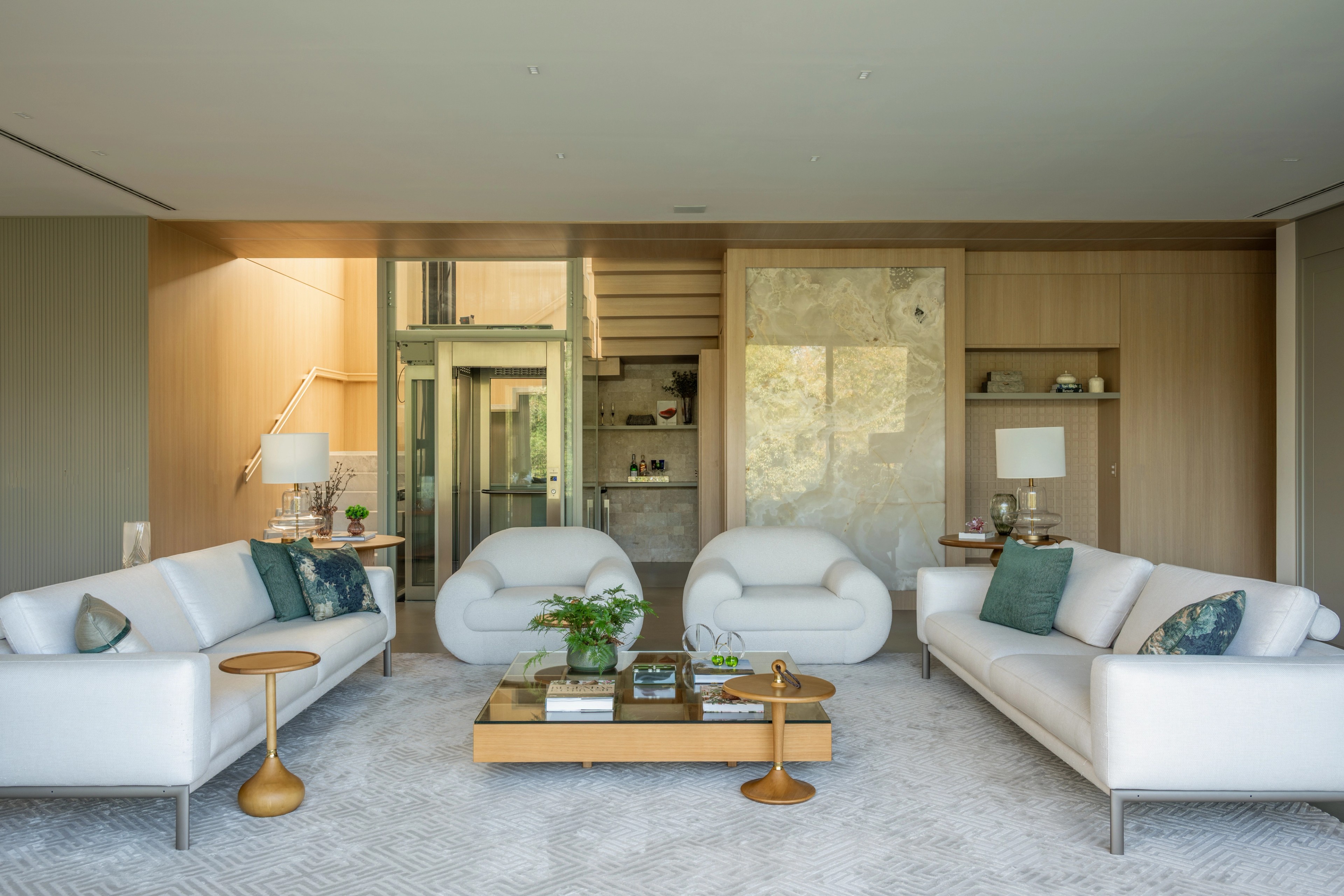 Residência SMI — Sala de estar com poltronas e painéis de madeira