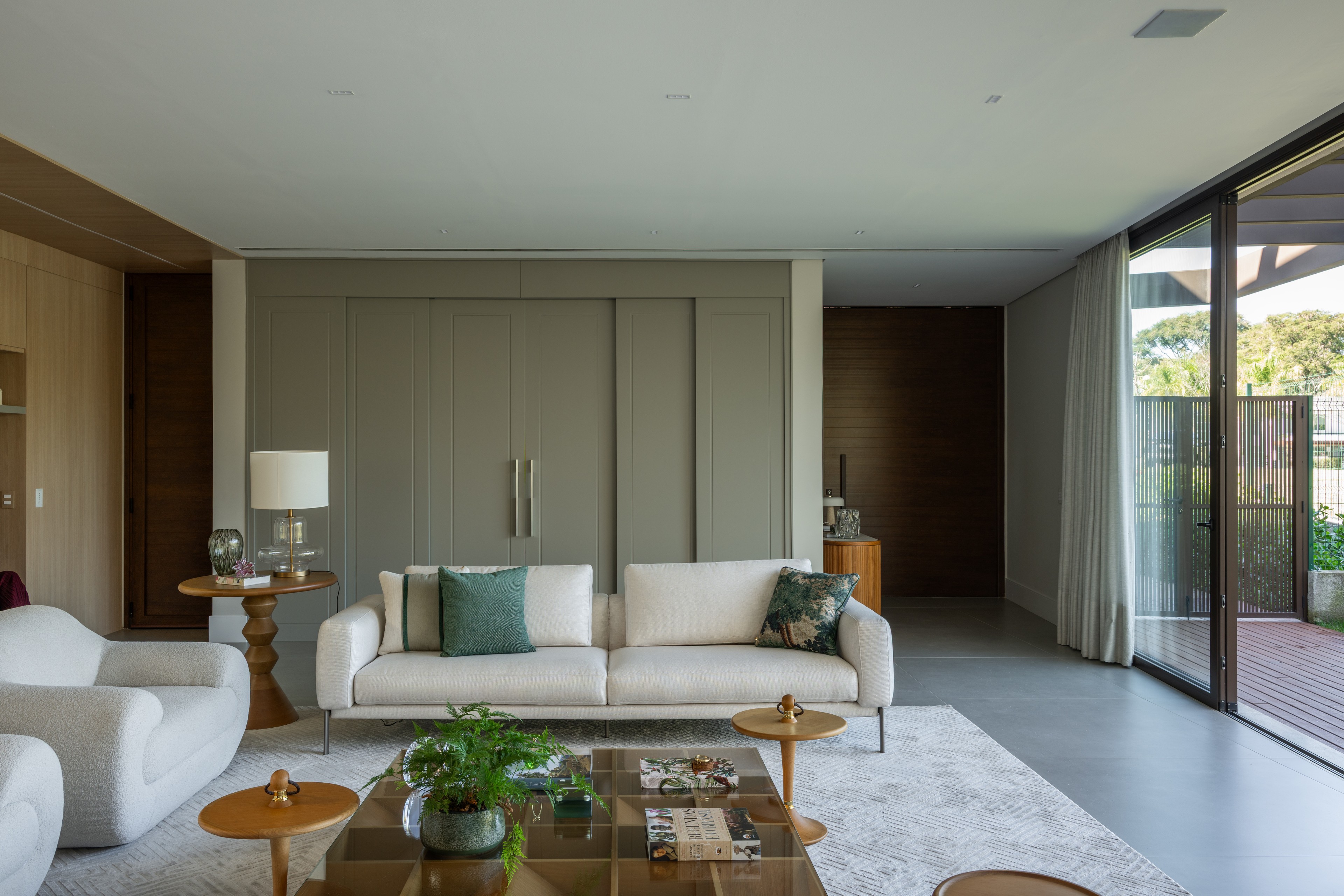 Residência SMI — Sala de estar com sofá e painel ao fundo