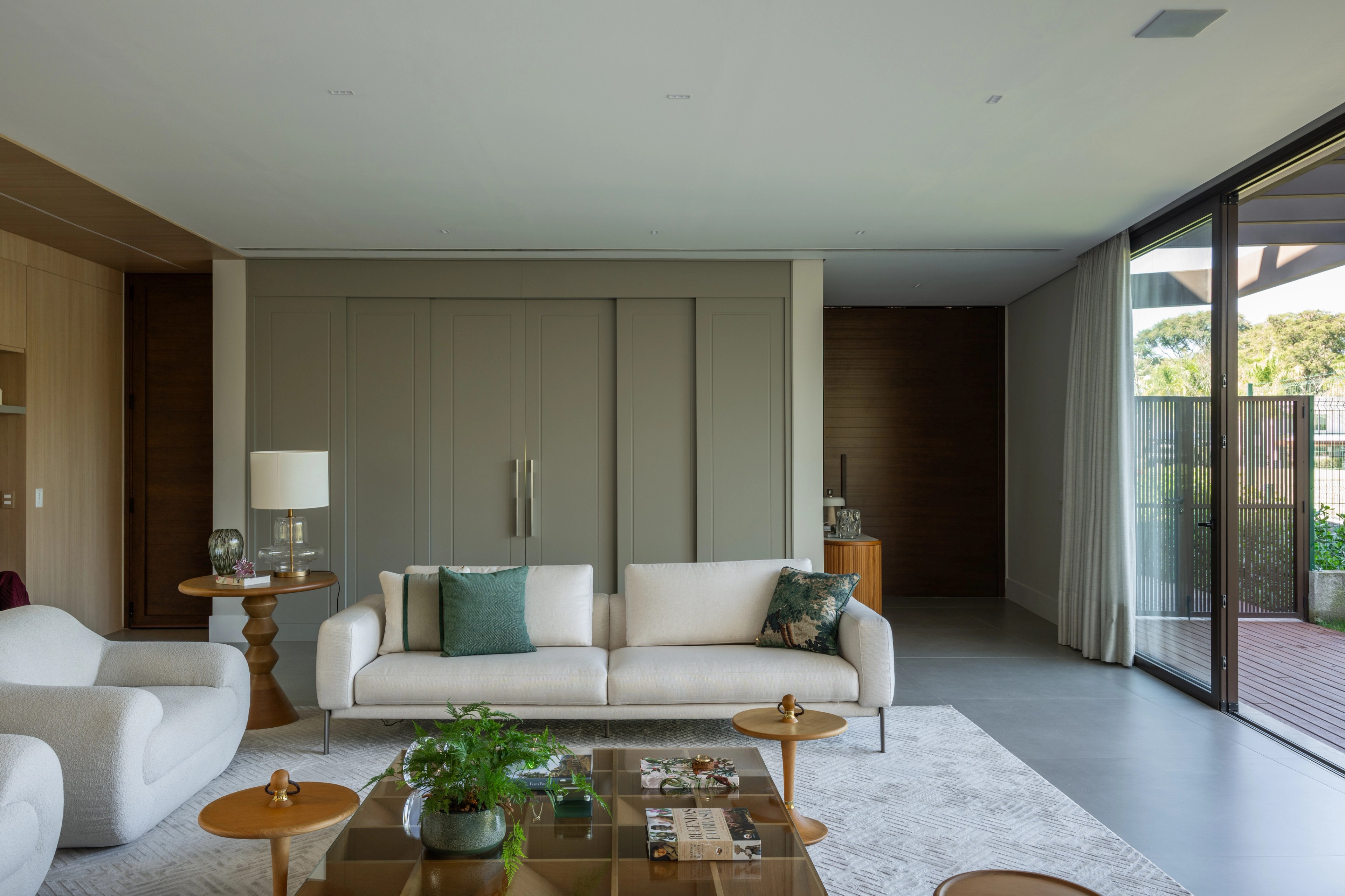 Residência SMI — Sala de estar com sofá e painel ao fundo