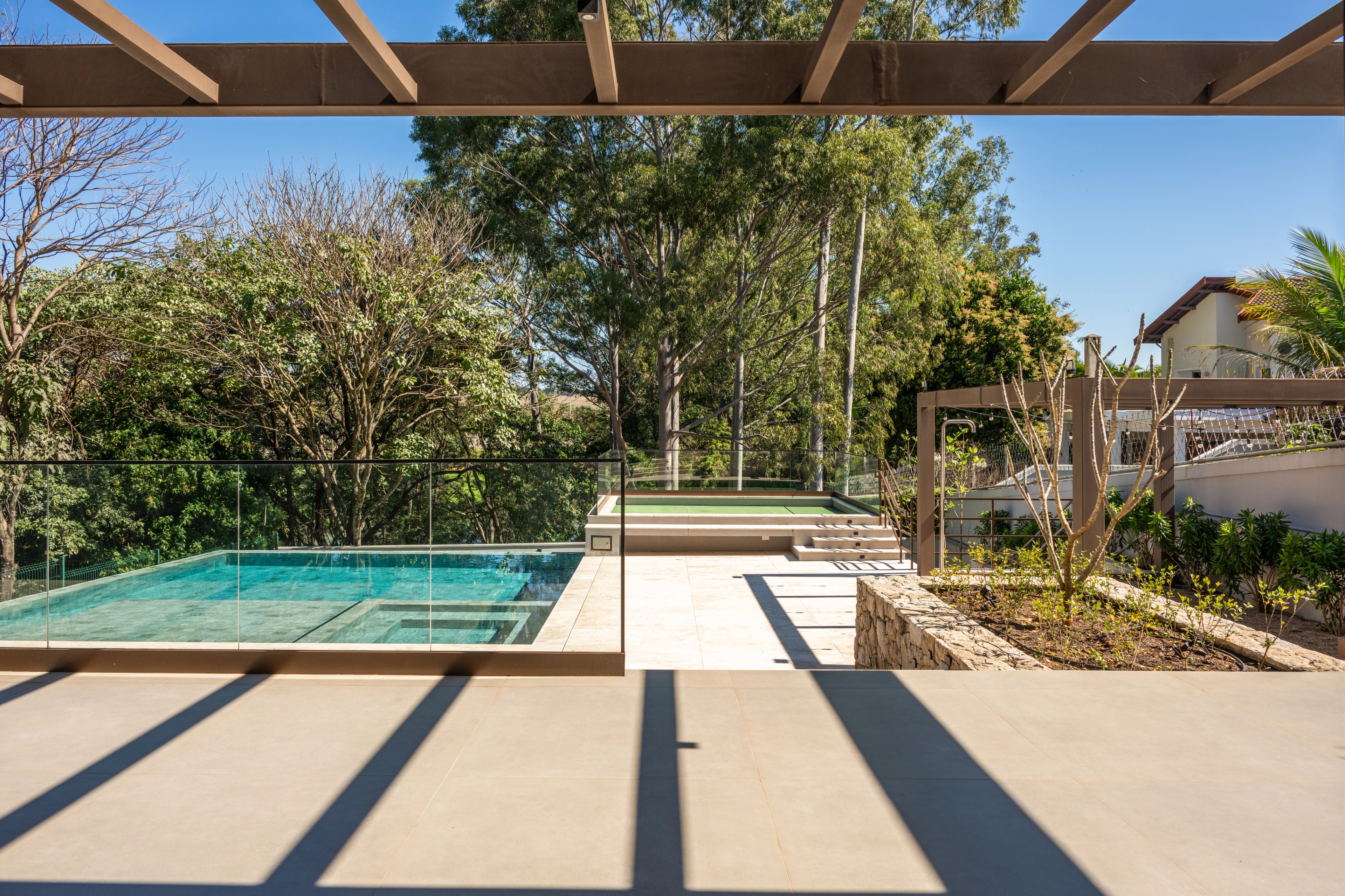 Residência SMI — Terraço com pergolado e vista para a piscina
