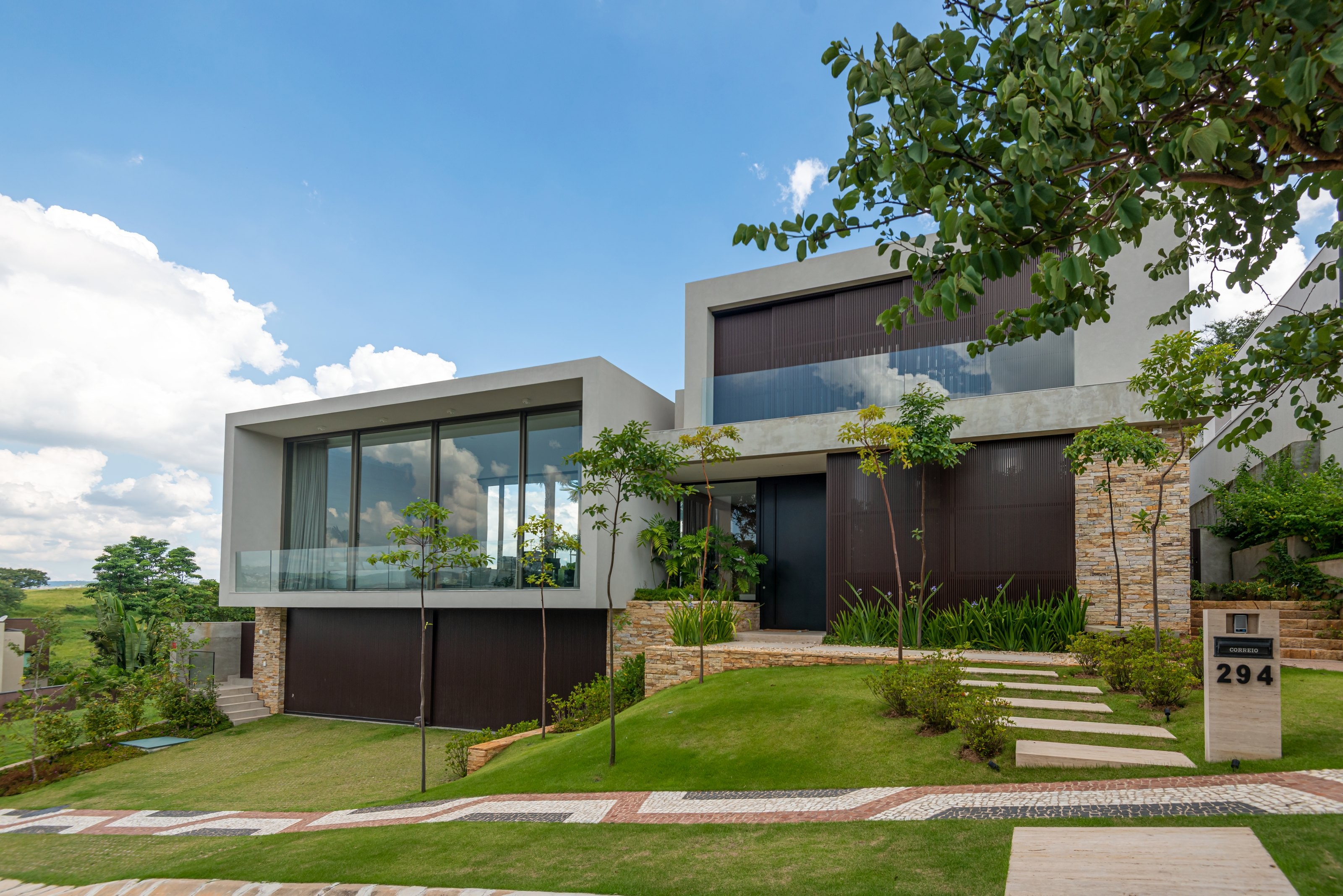 Residência GAM — Fachada frontal com paisagismo