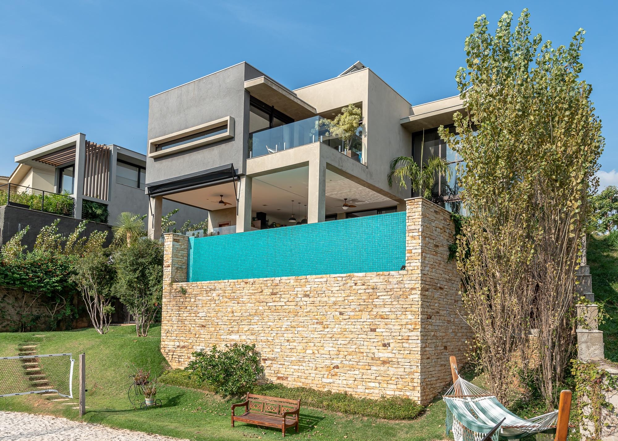 Residência DUA — Fachada lateral com piscina elevada