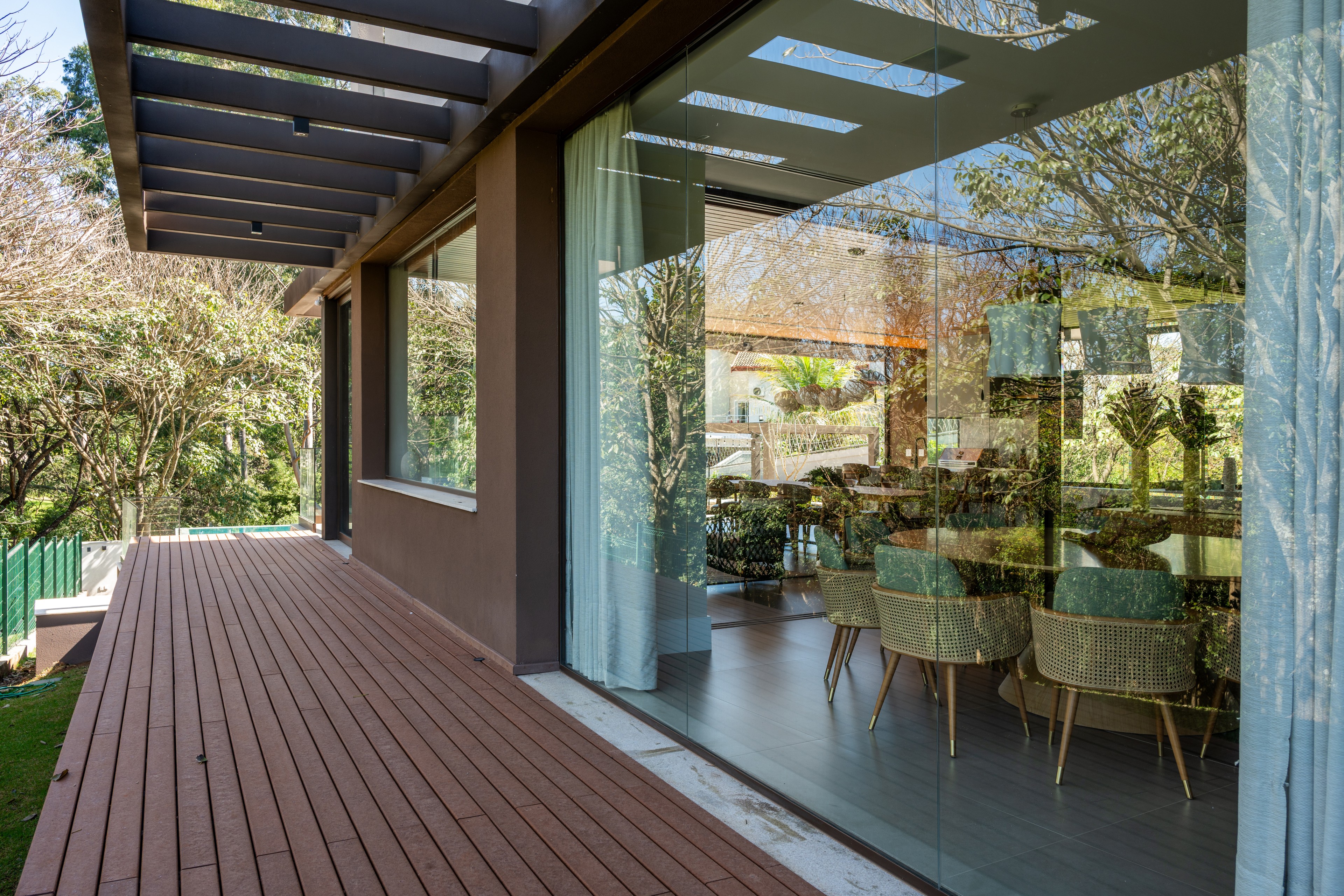 Residência SMI — Sala de jantar vista pelas portas de vidro do deck