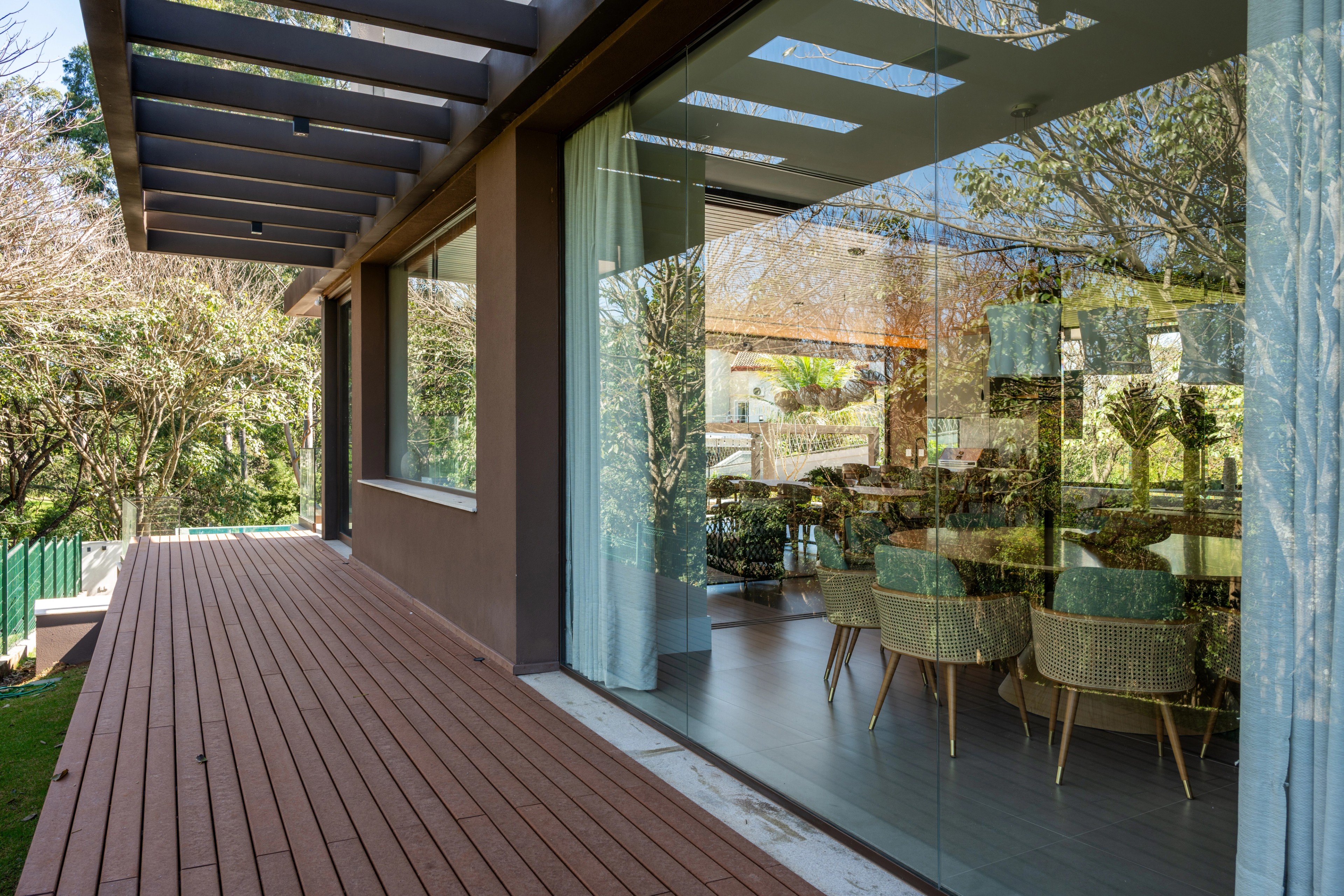 Residência SMI — Sala de jantar vista pelas portas de vidro do deck