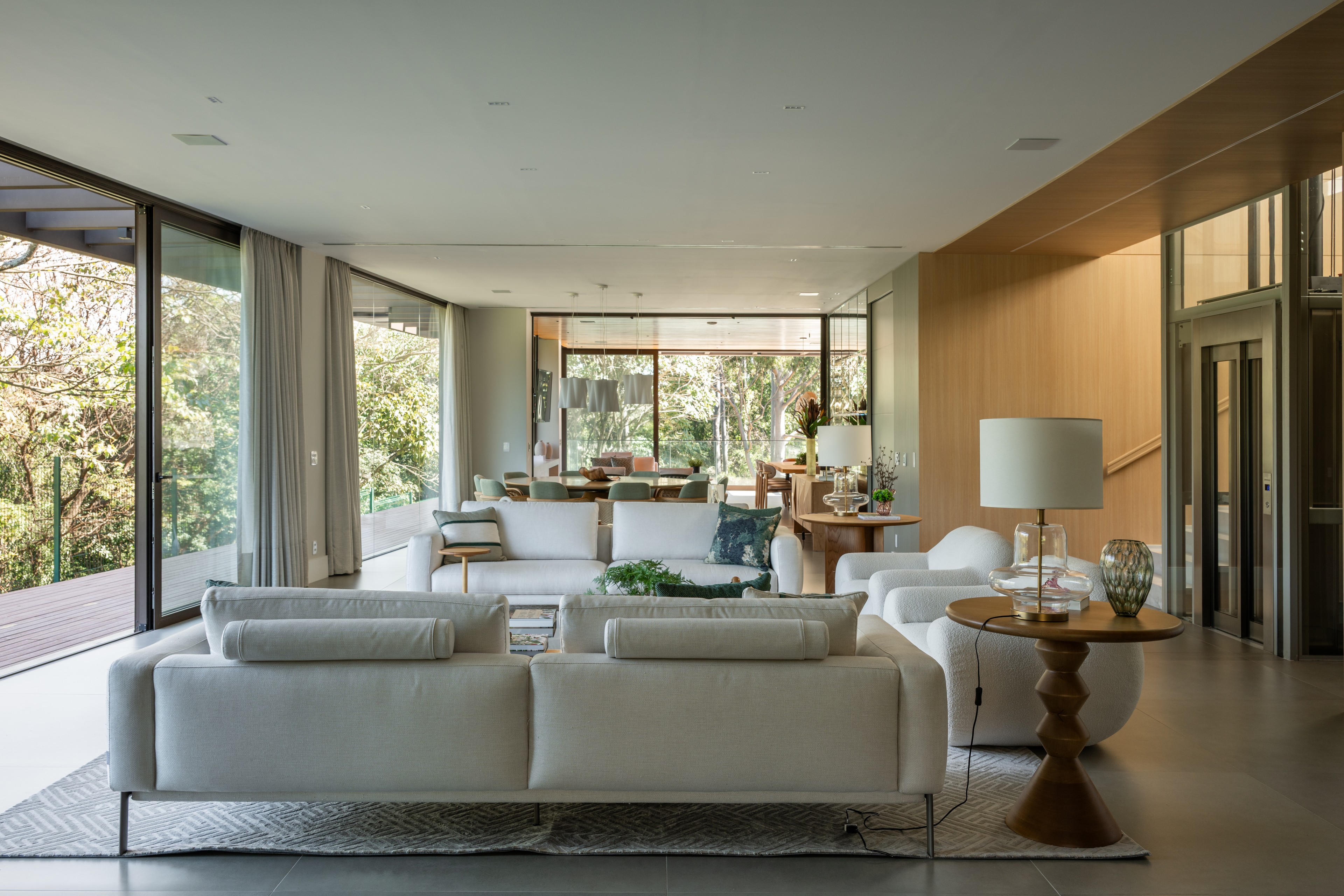 Residência SMI — Sala de estar e jantar integradas com vista para o jardim