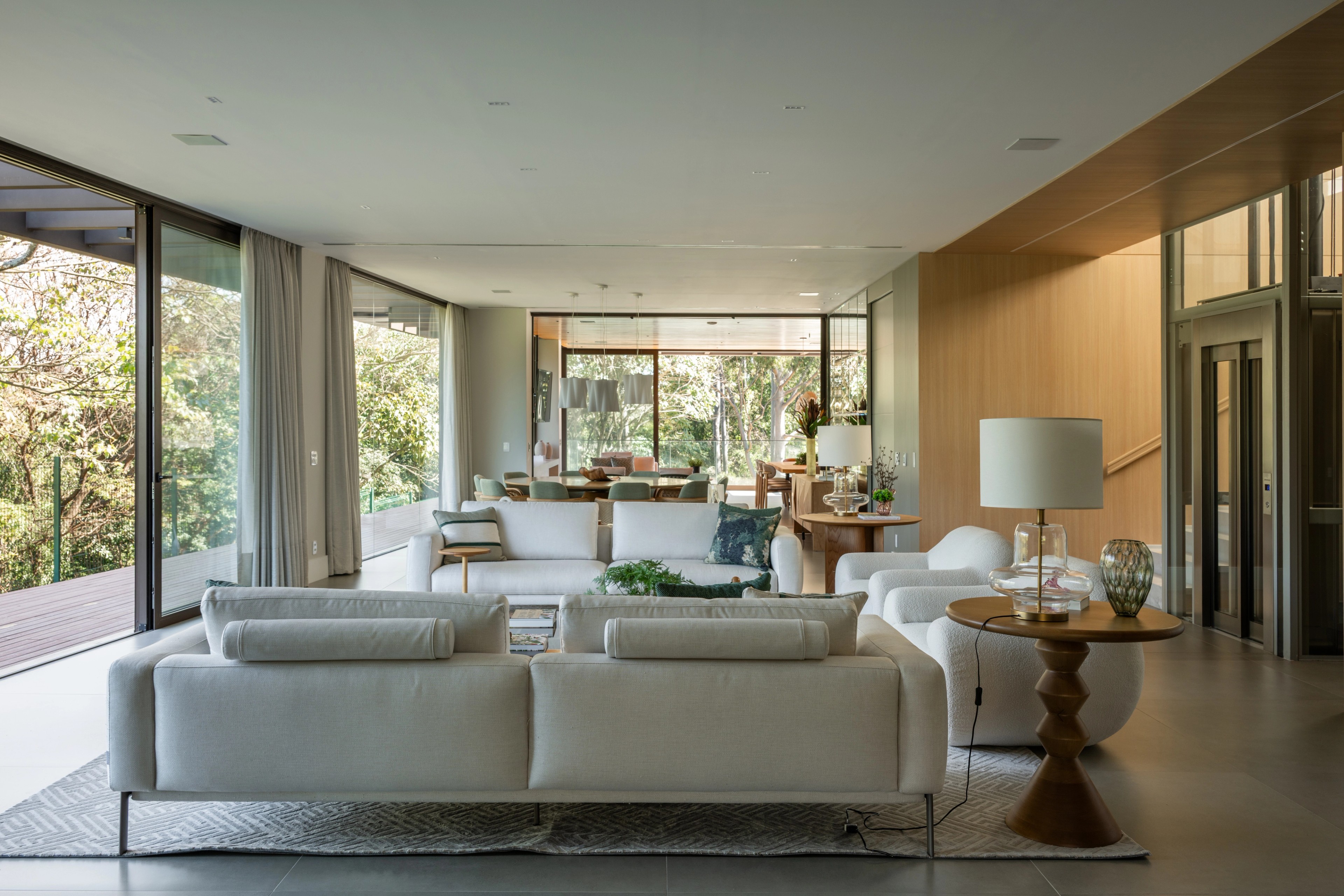 Residência SMI — Sala de estar e jantar integradas com vista para o jardim