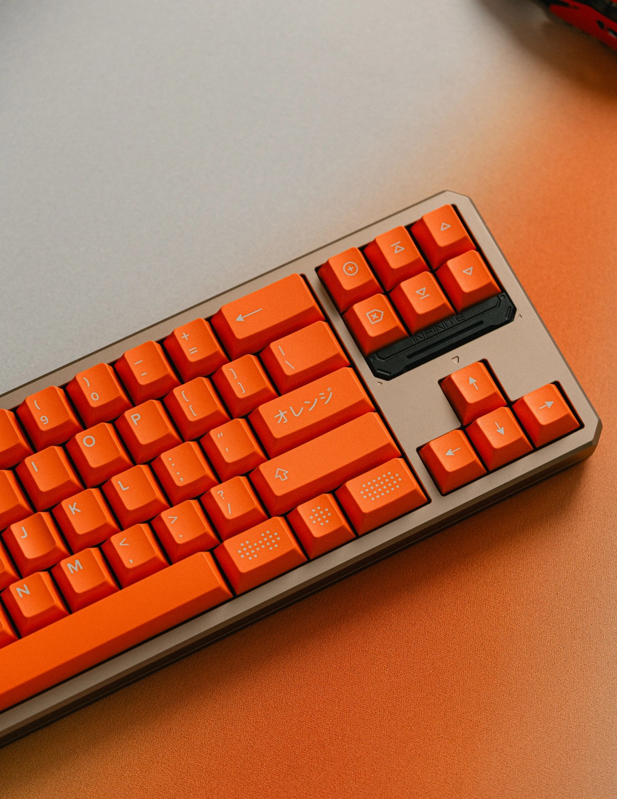 Close-up of an orange keycap set on a beige mechanical keyboard.