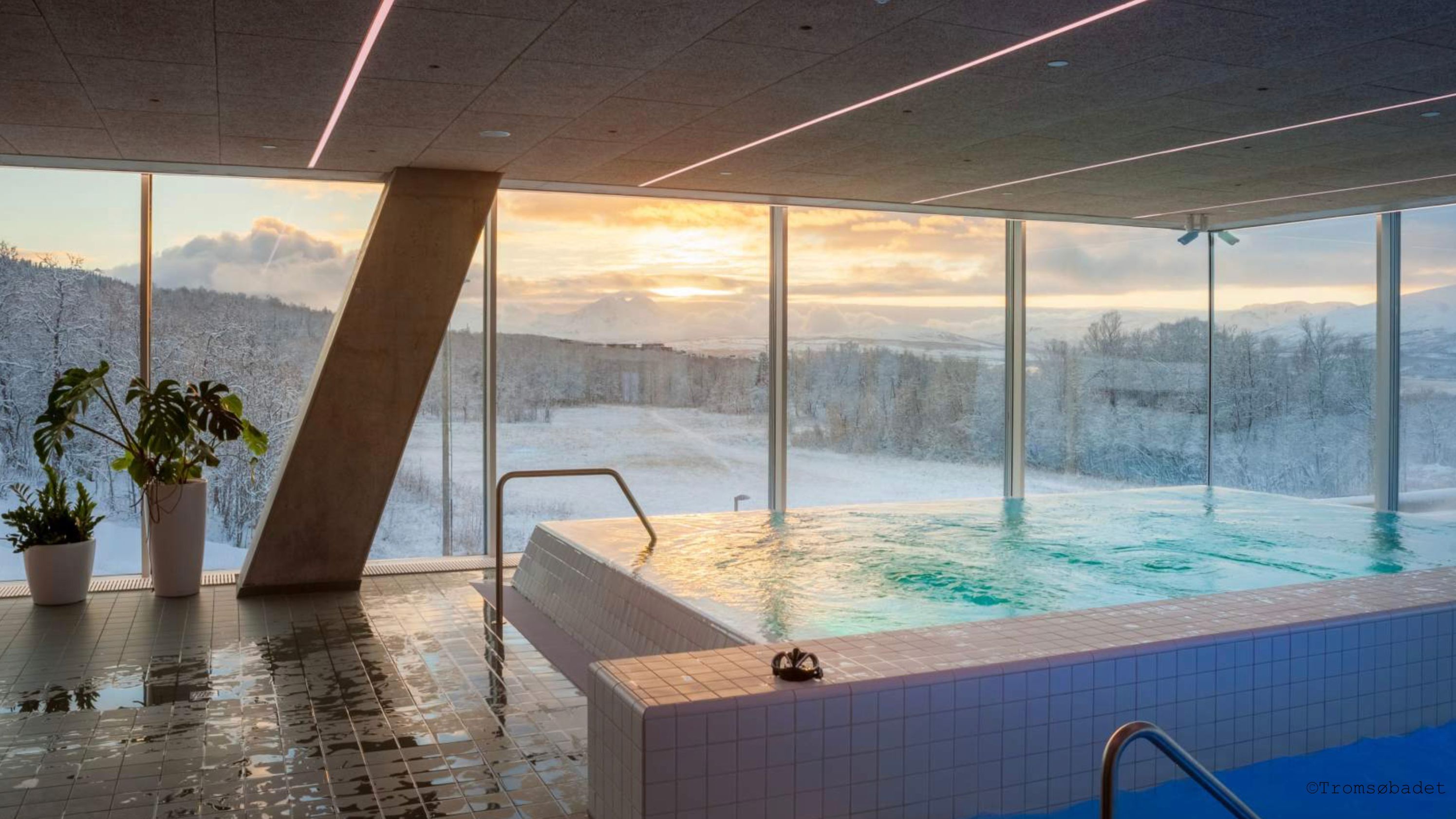 Indoor heated pool at Tromsøbadet during winter with sunset in the south