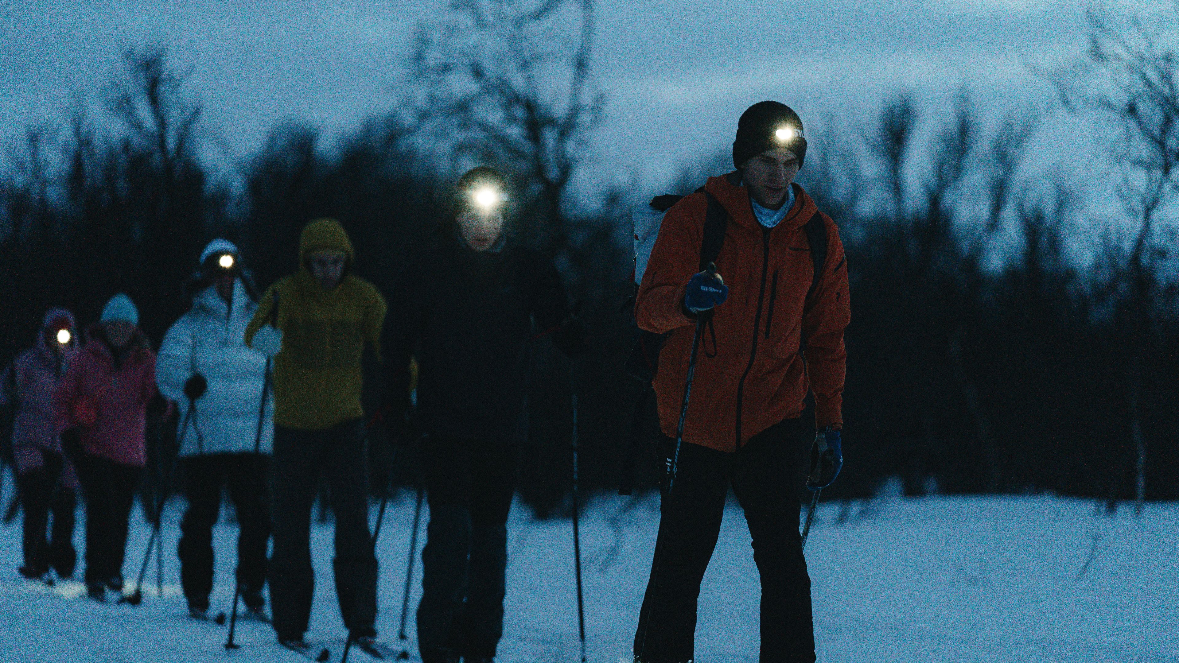 Skiiers exploring the wilderness under the Northern light