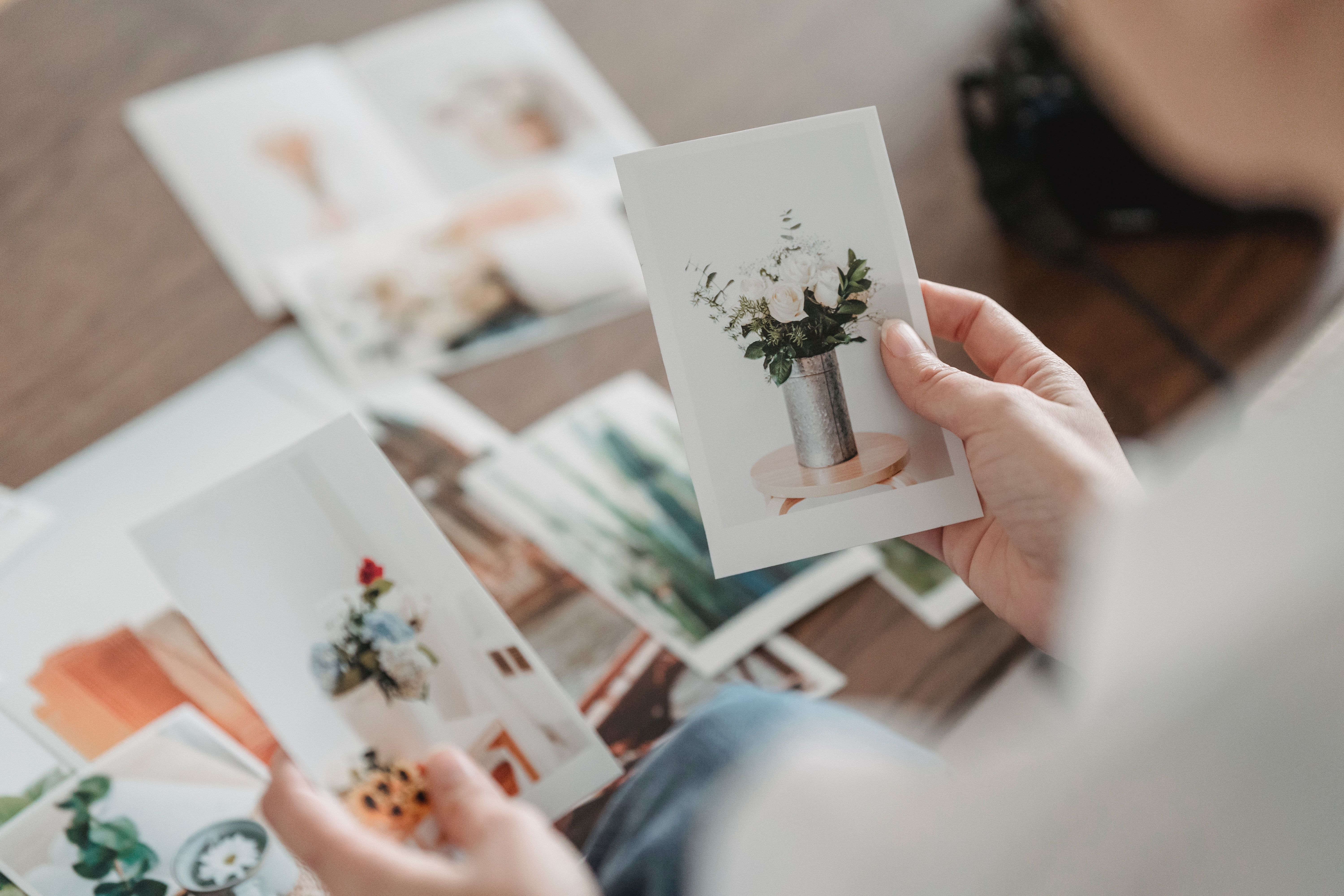 Picture of a woman comparing photos of flowers at table