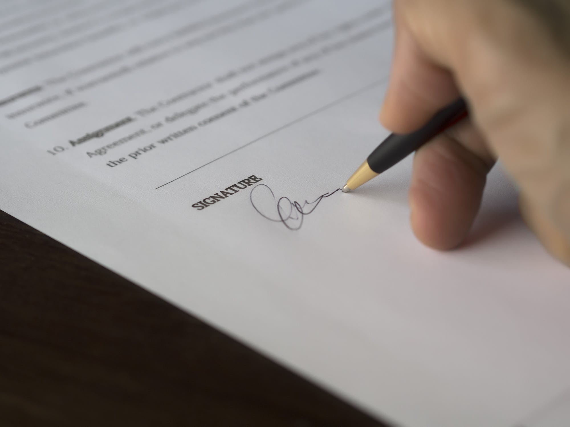 A hand signing financial paperwork