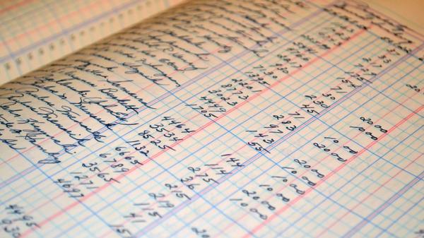 An accounting ledger written on white graphing paper