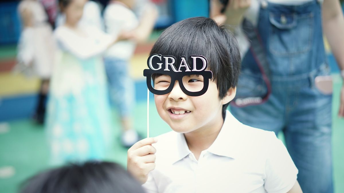 A child wearing grad cap